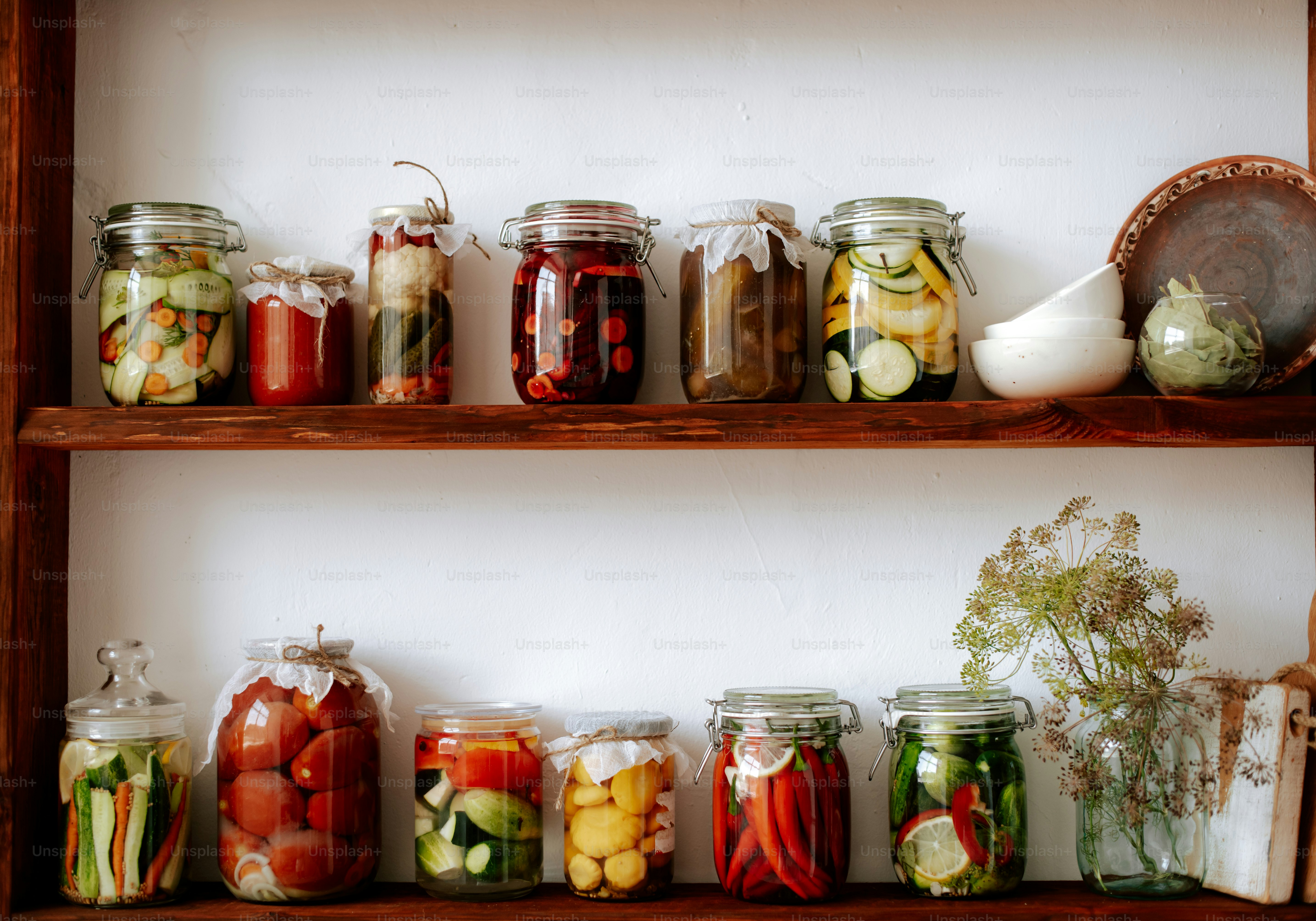 A shelf filled with jars filled with different types of food