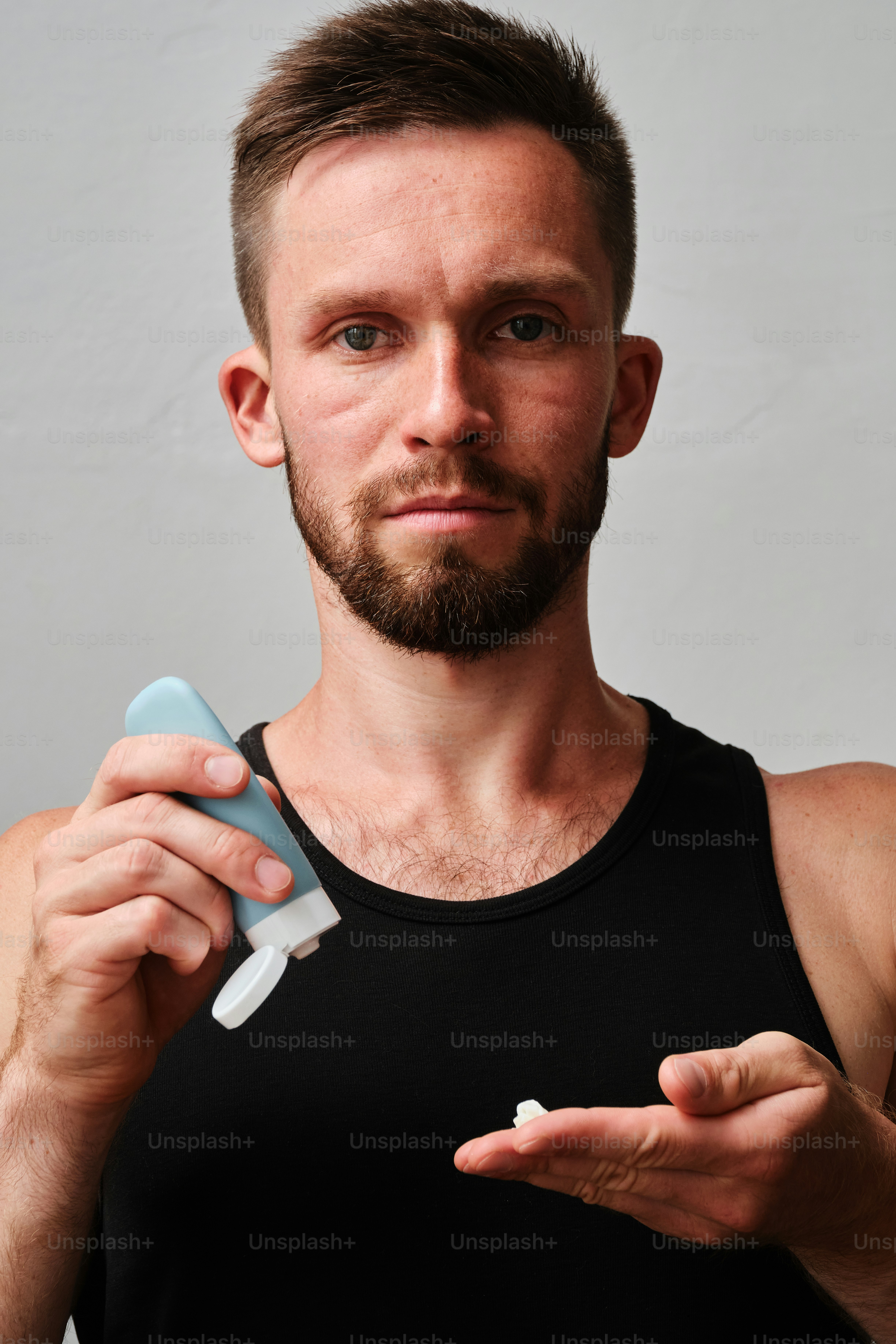 A man holding a toothbrush and a tube of toothpaste