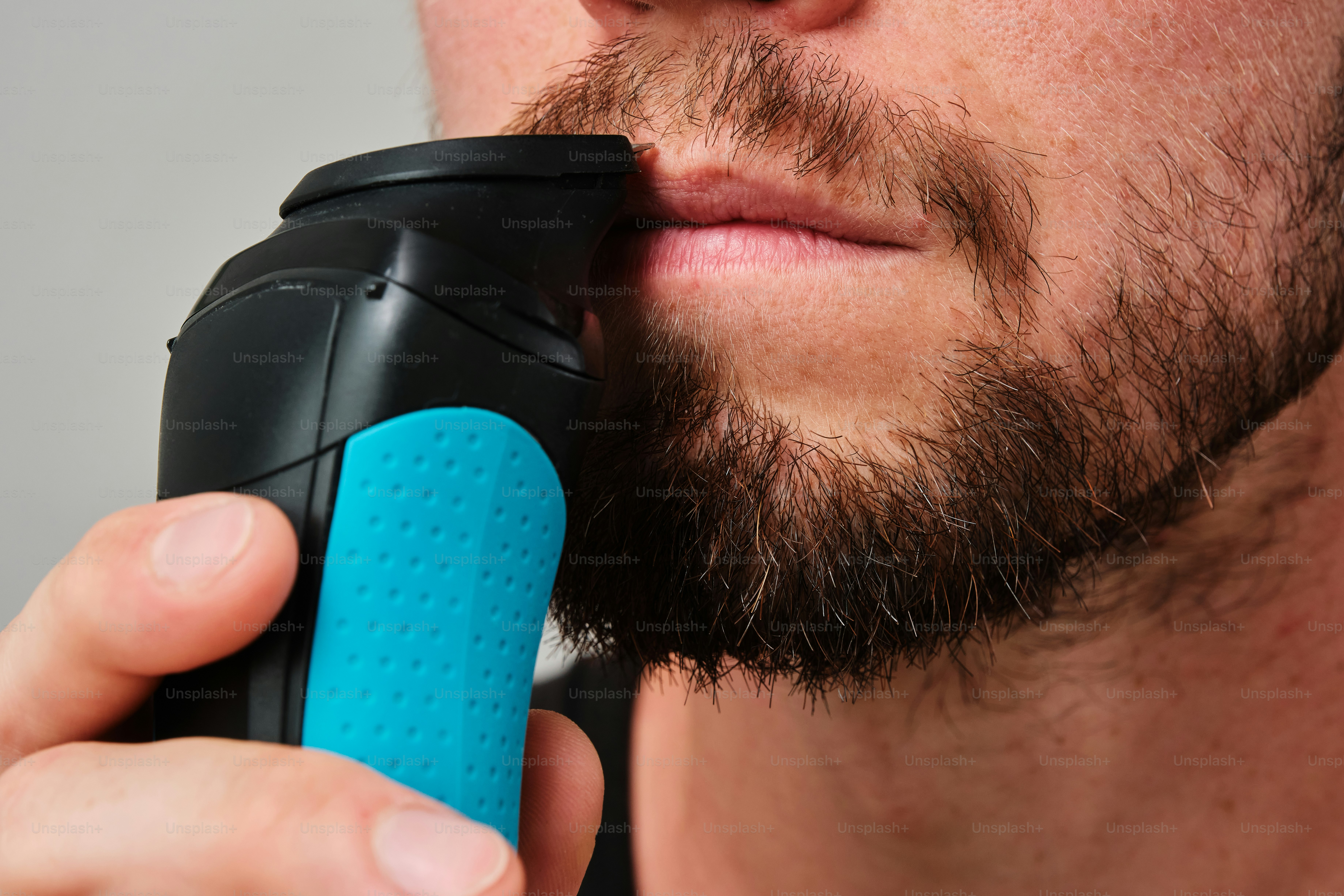 A man with a beard and a blue object in his hand