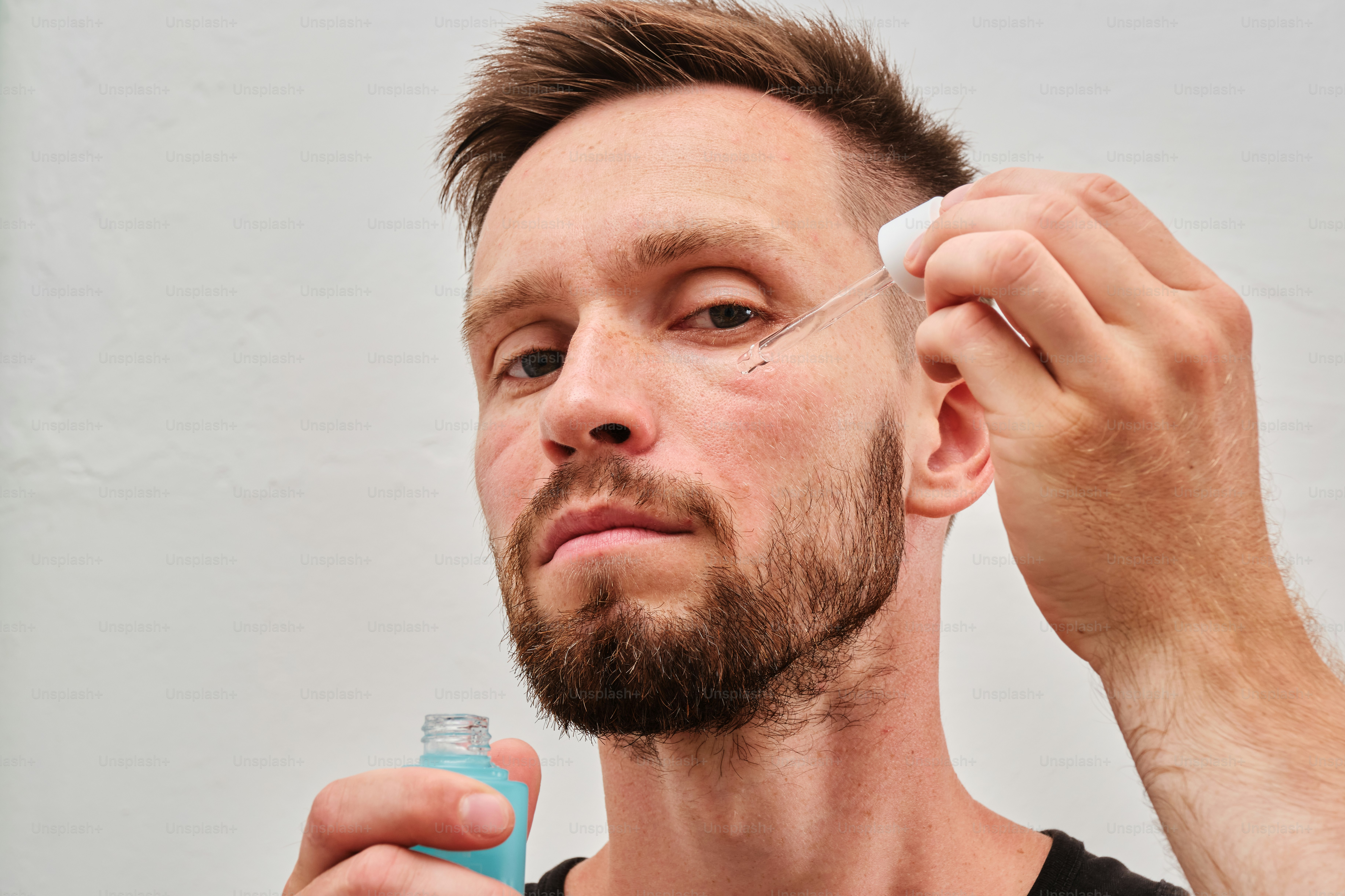 Um homem está raspando o cabelo com um barbeador elétrico