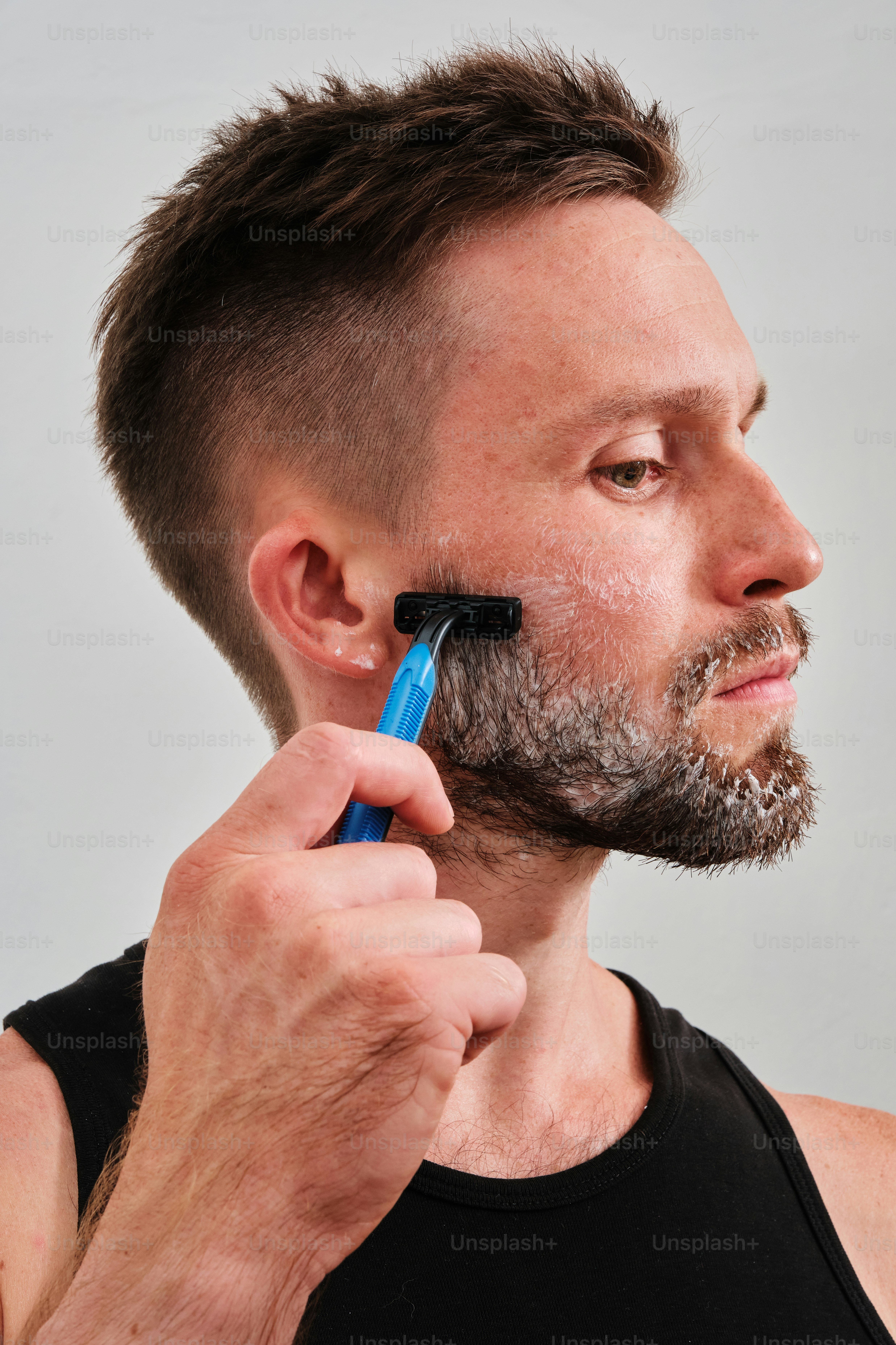 A man shaving his face with an electric razor