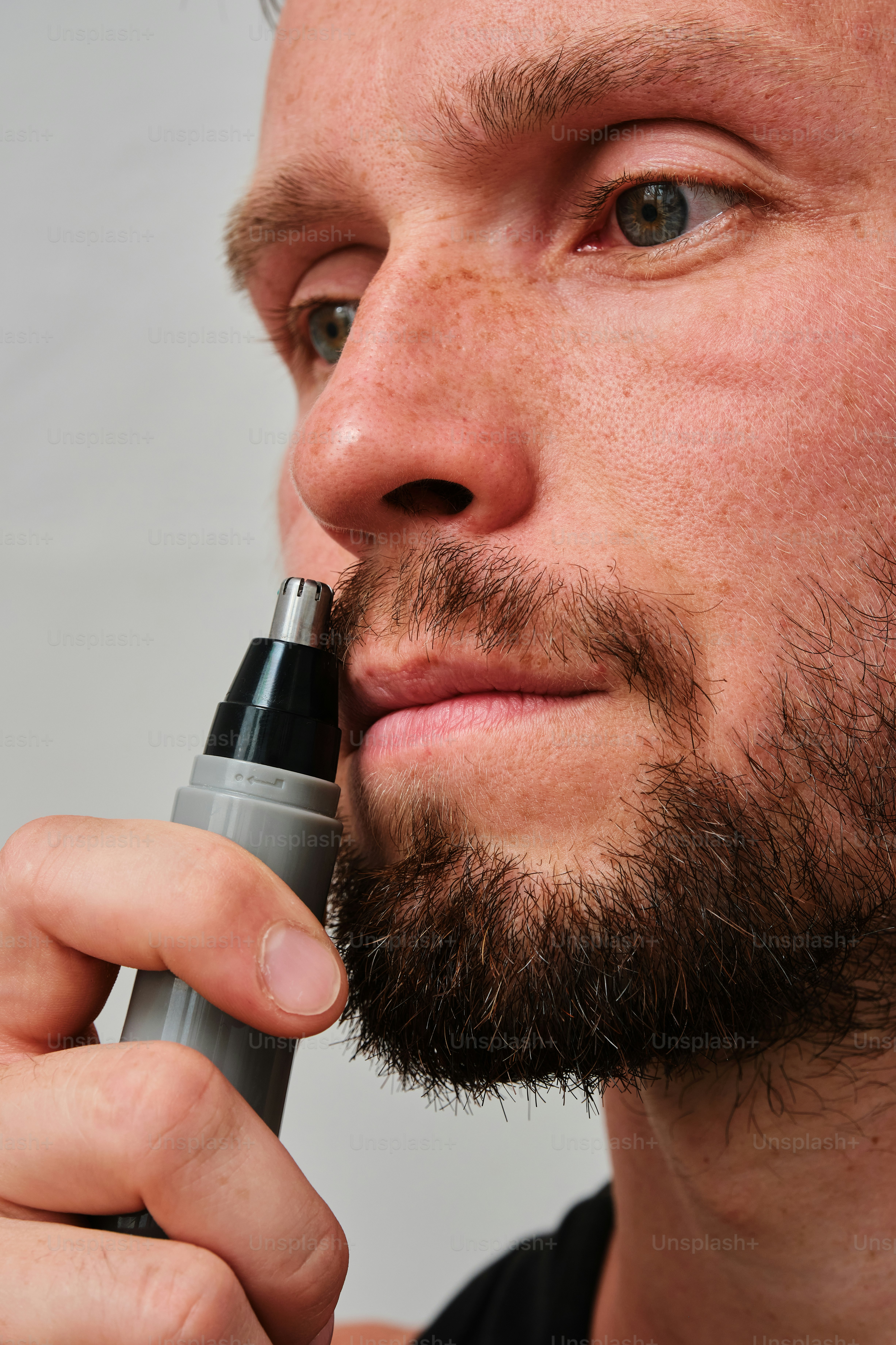 Un uomo con la barba e una penna in mano