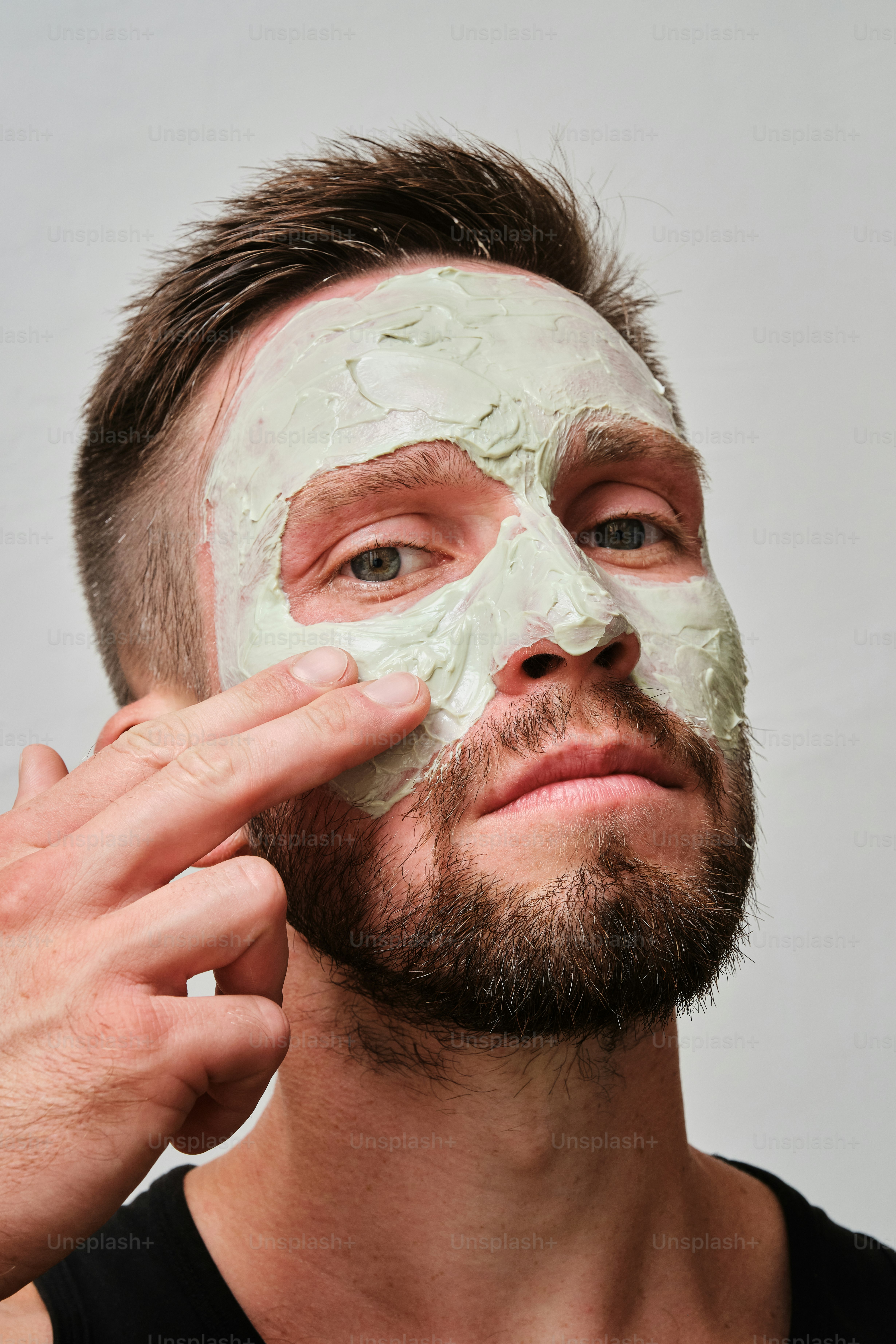 Un uomo si sta mettendo una maschera facciale sul viso