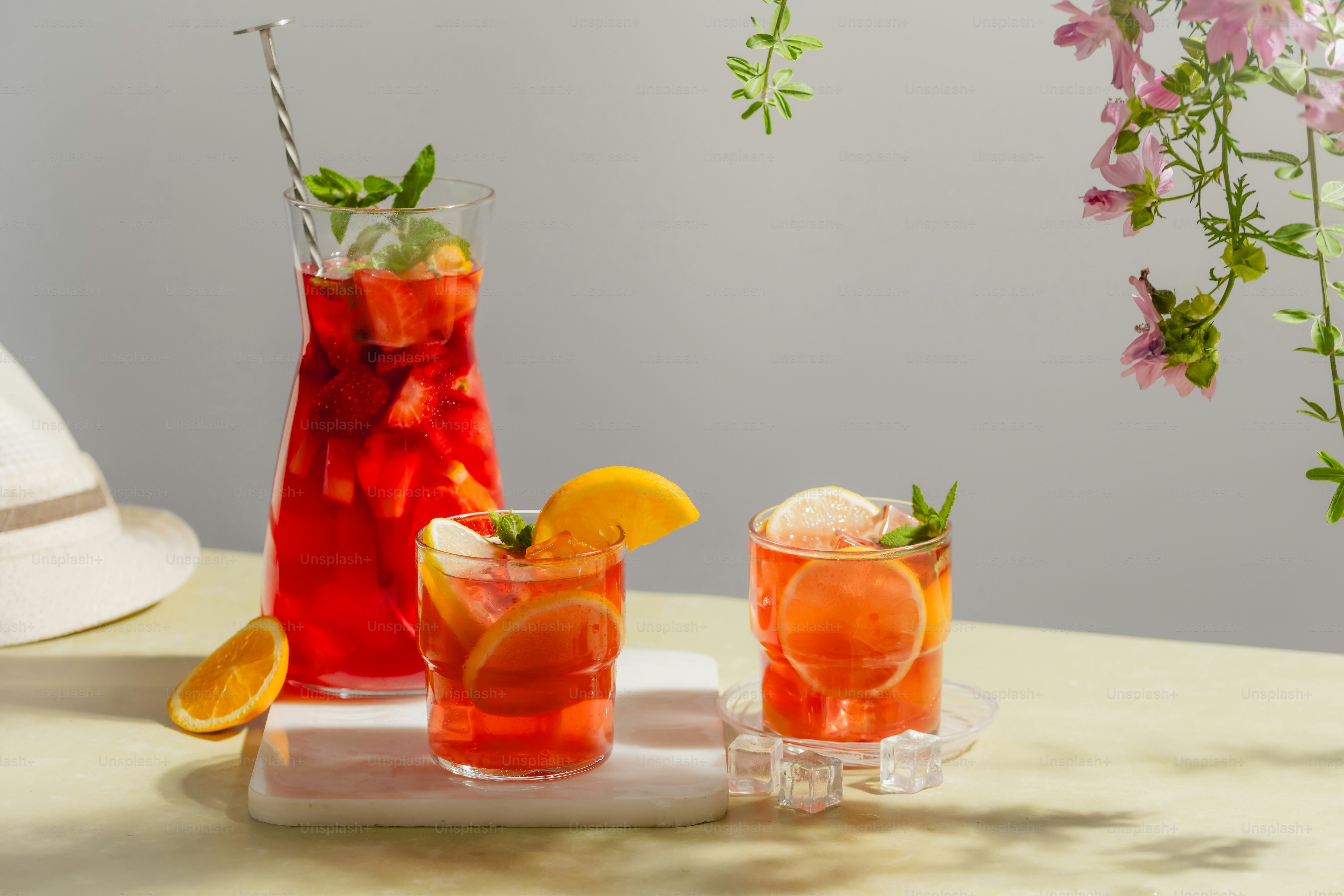 Una mesa cubierta con tres vasos llenos de bebidas