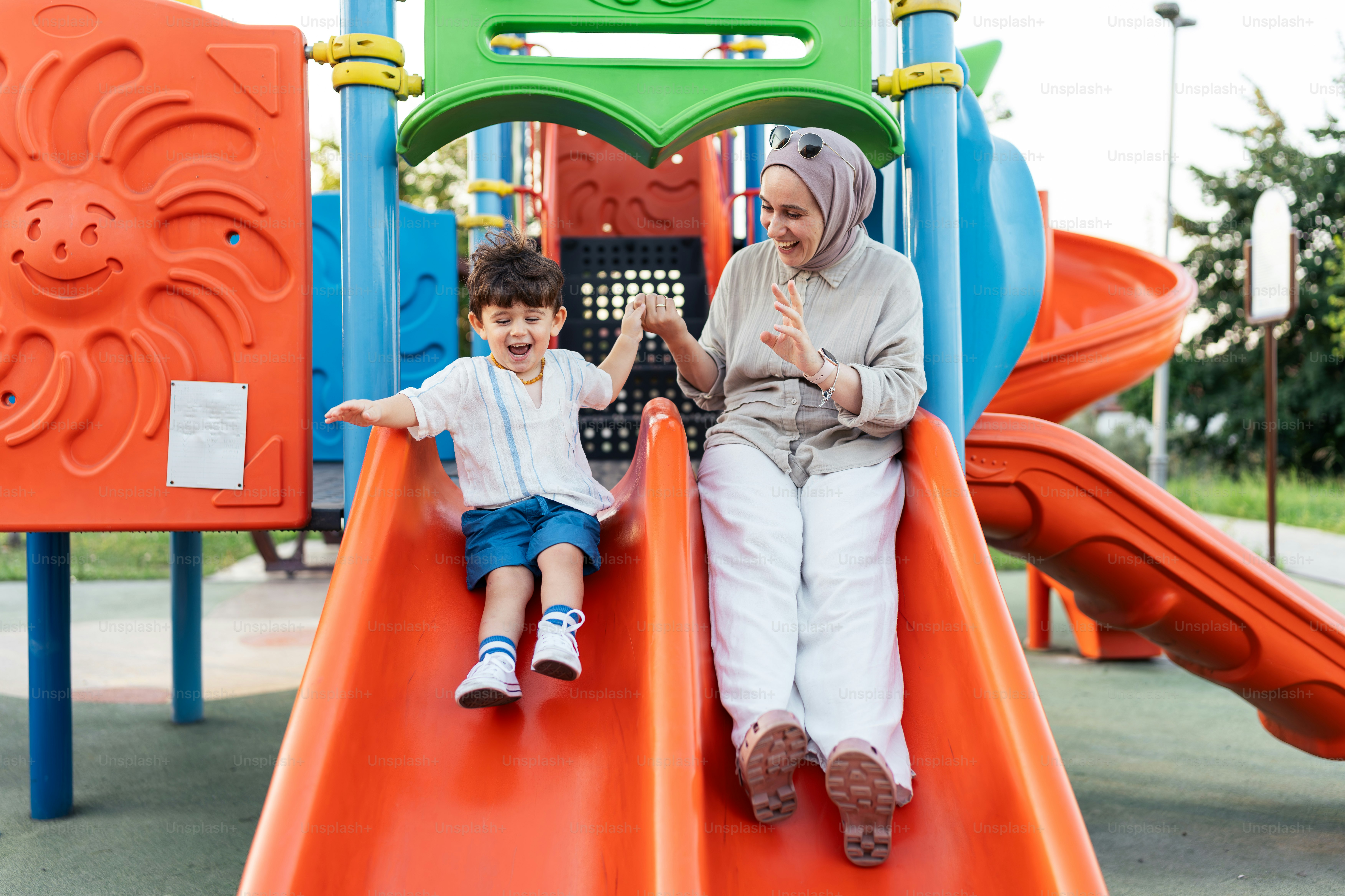 Una mujer y un niño sentados en un tobogán