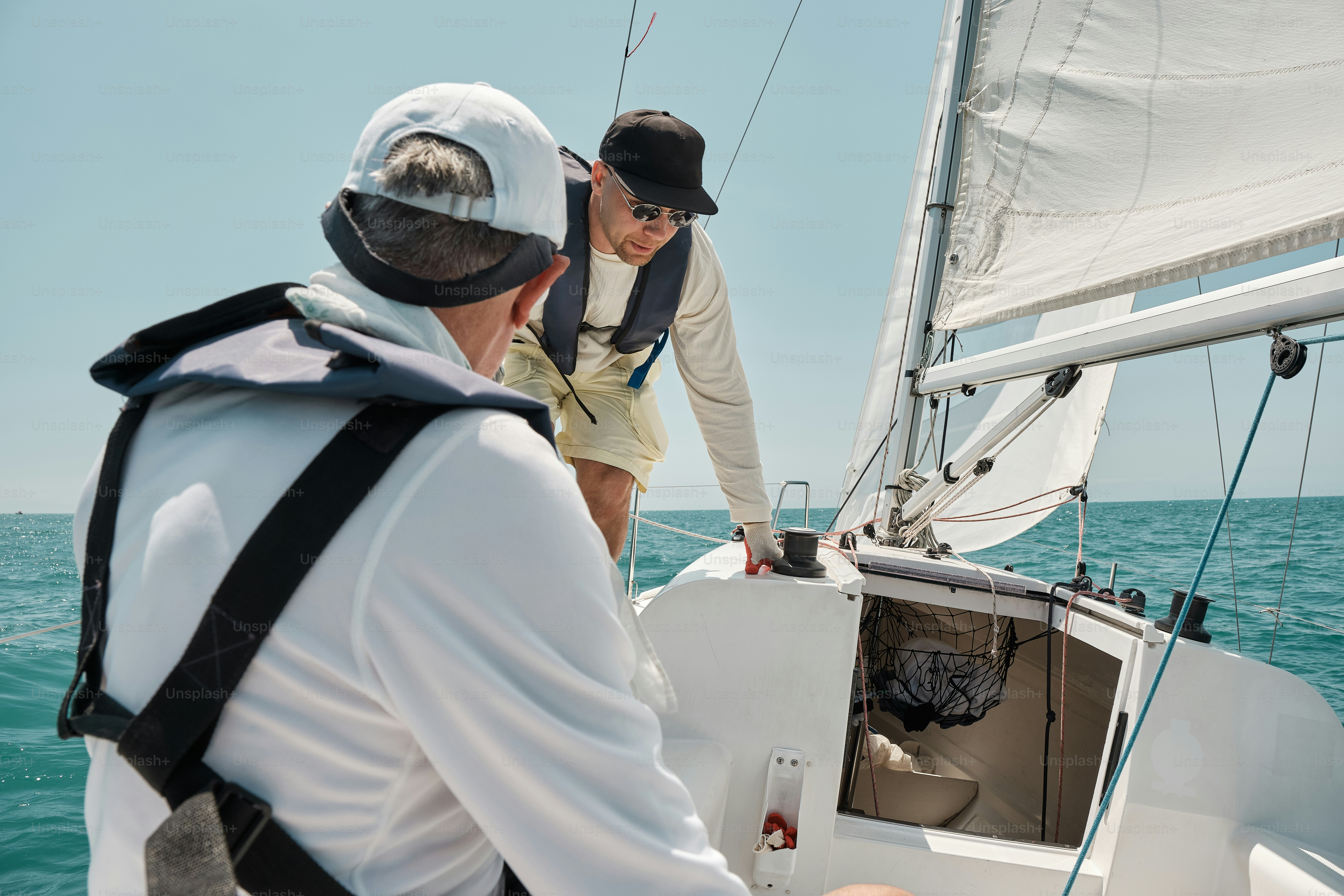 A man and a woman on a sailboat in the ocean