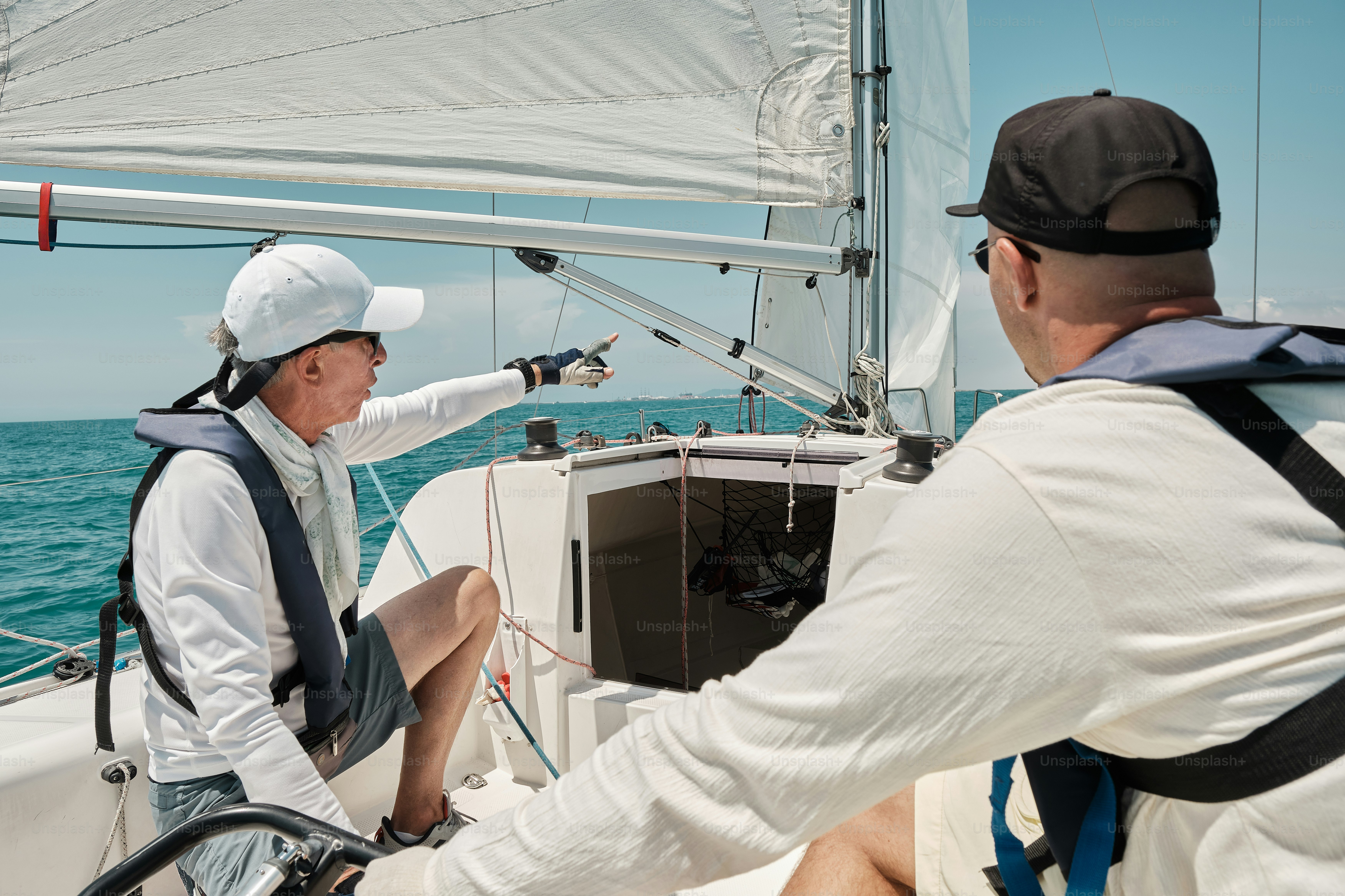 A man and a woman on a sailboat in the ocean