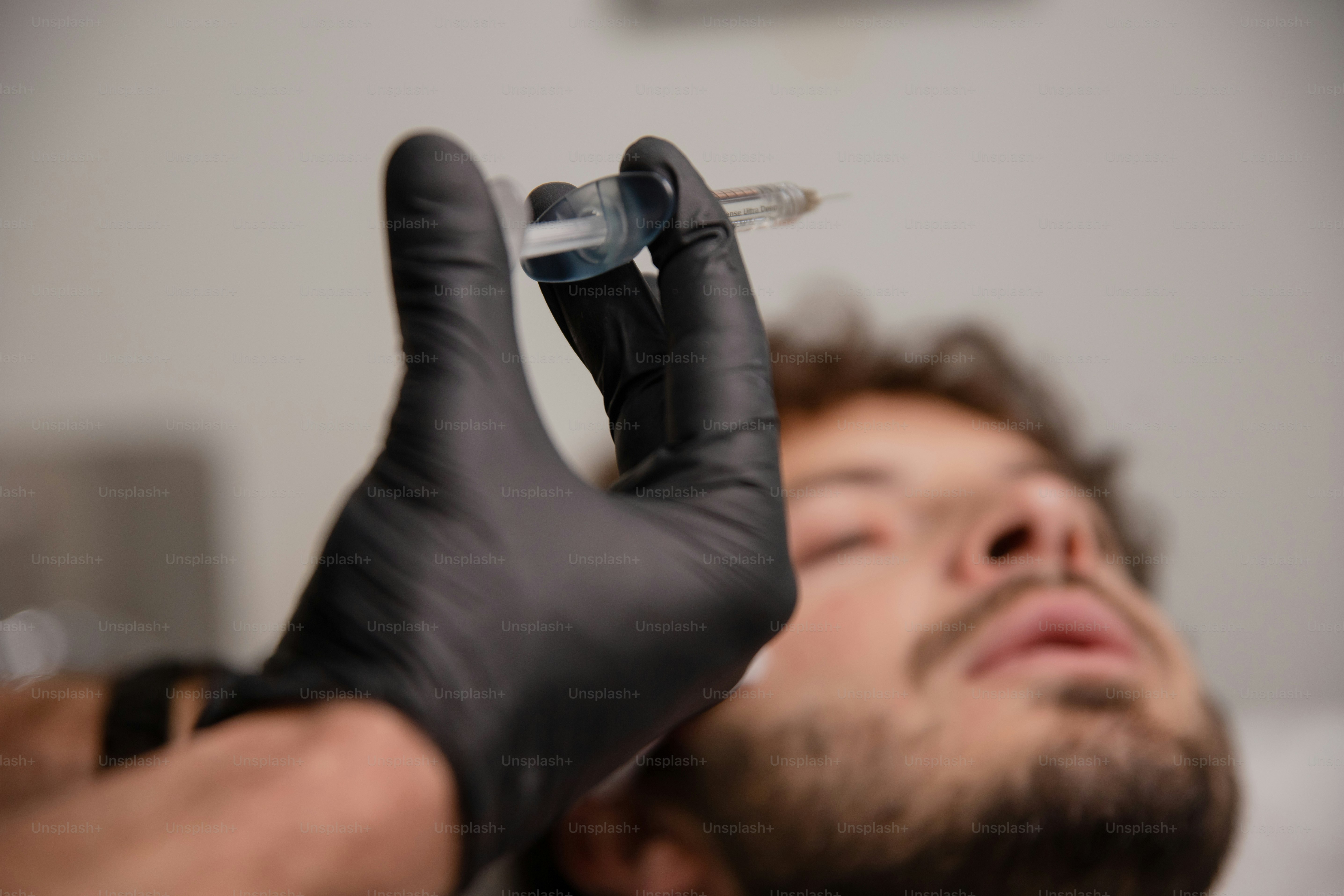 Un hombre acostado en la cama con un guante en la mano
