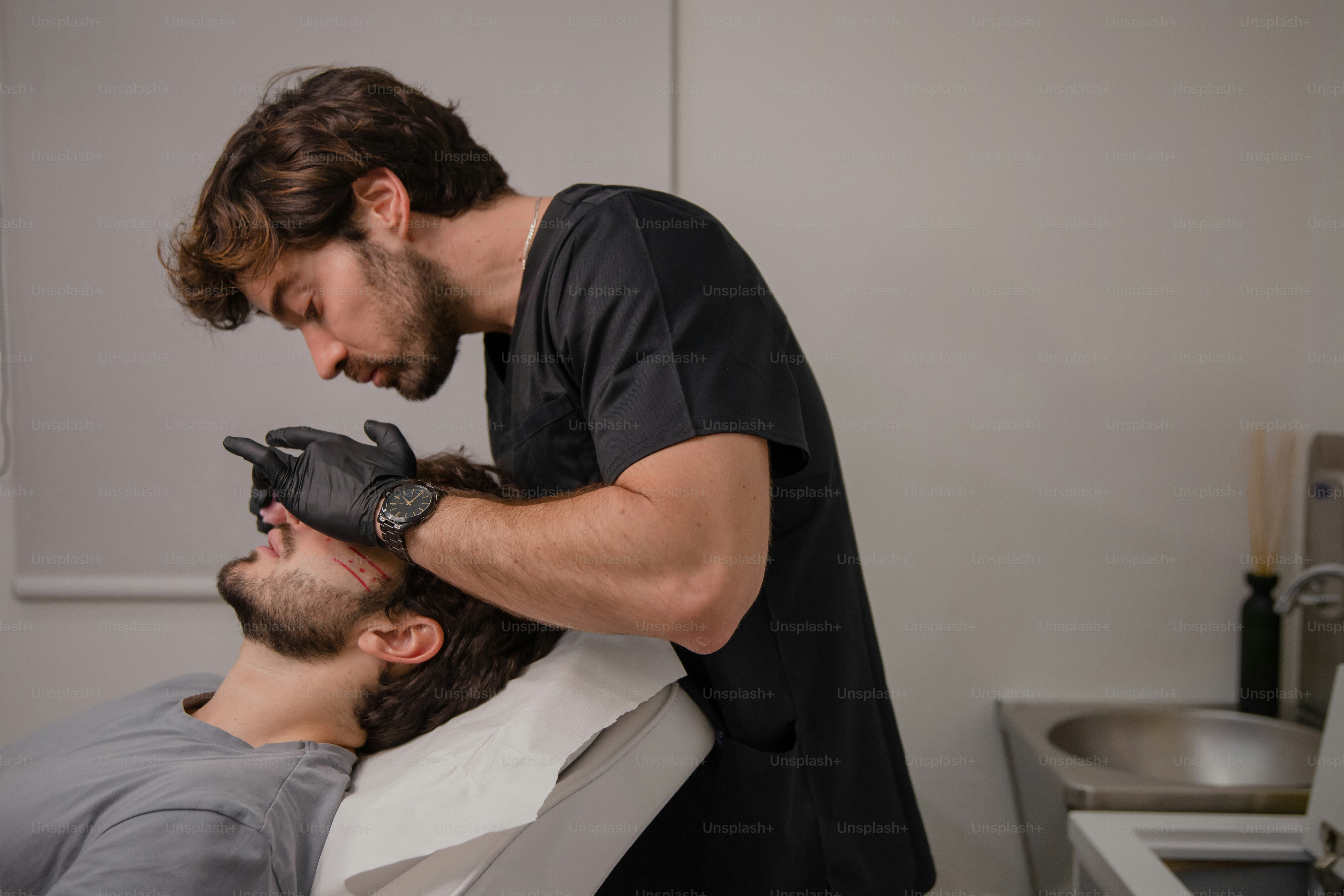 A man cutting another man's hair in a barber shop