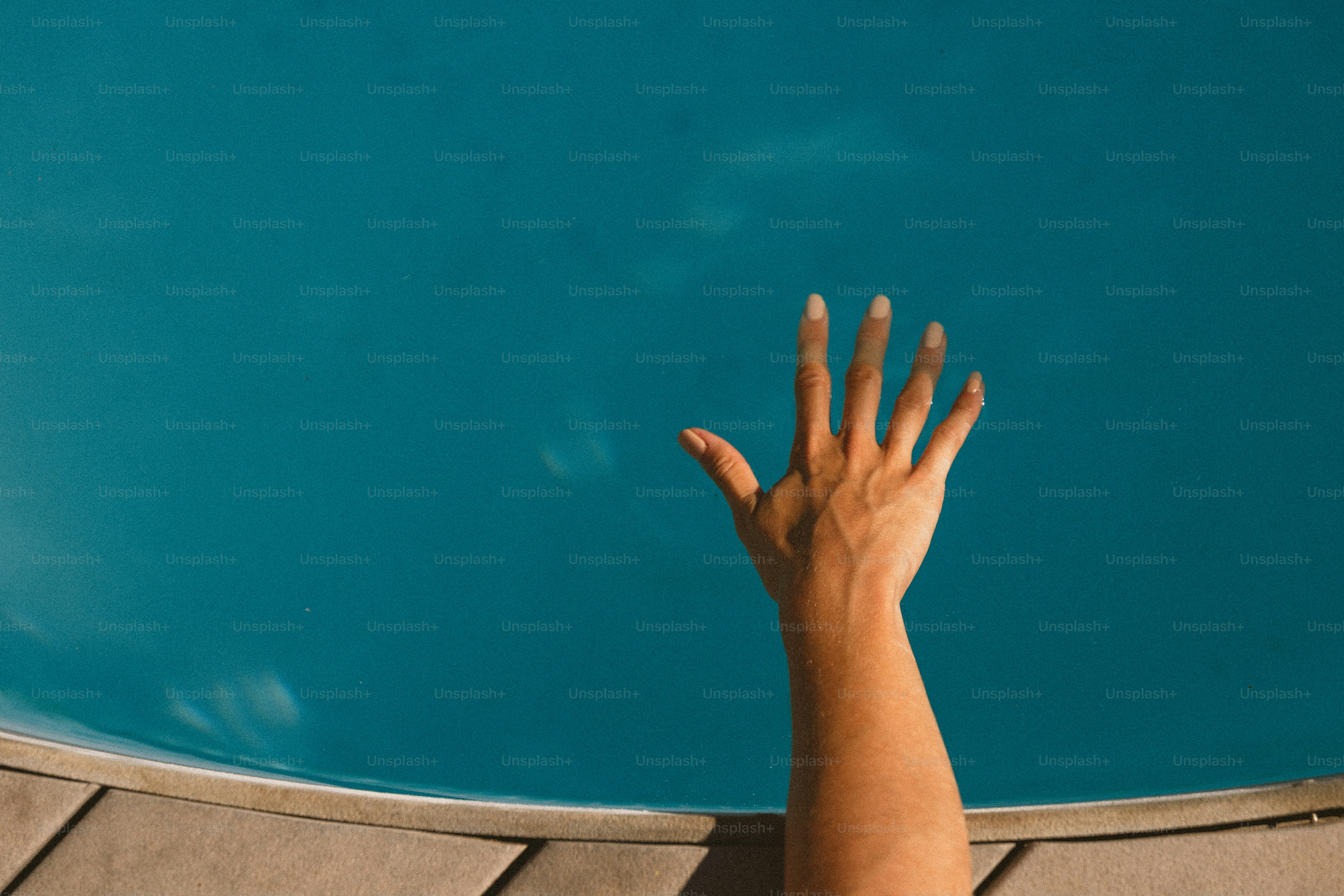 Une personne qui tend la main dans une piscine pour attraper un frisbee