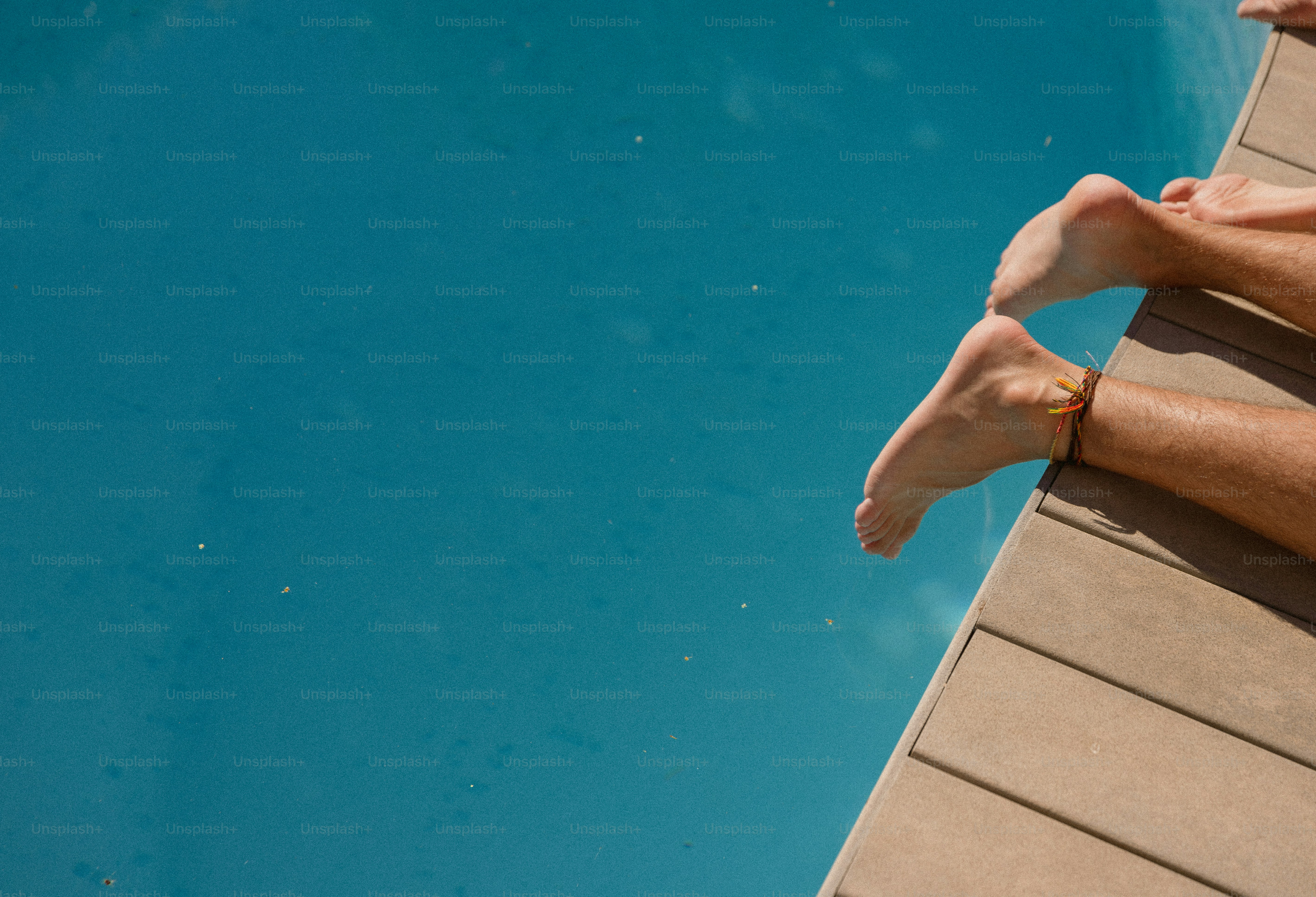 A person laying on the edge of a swimming pool