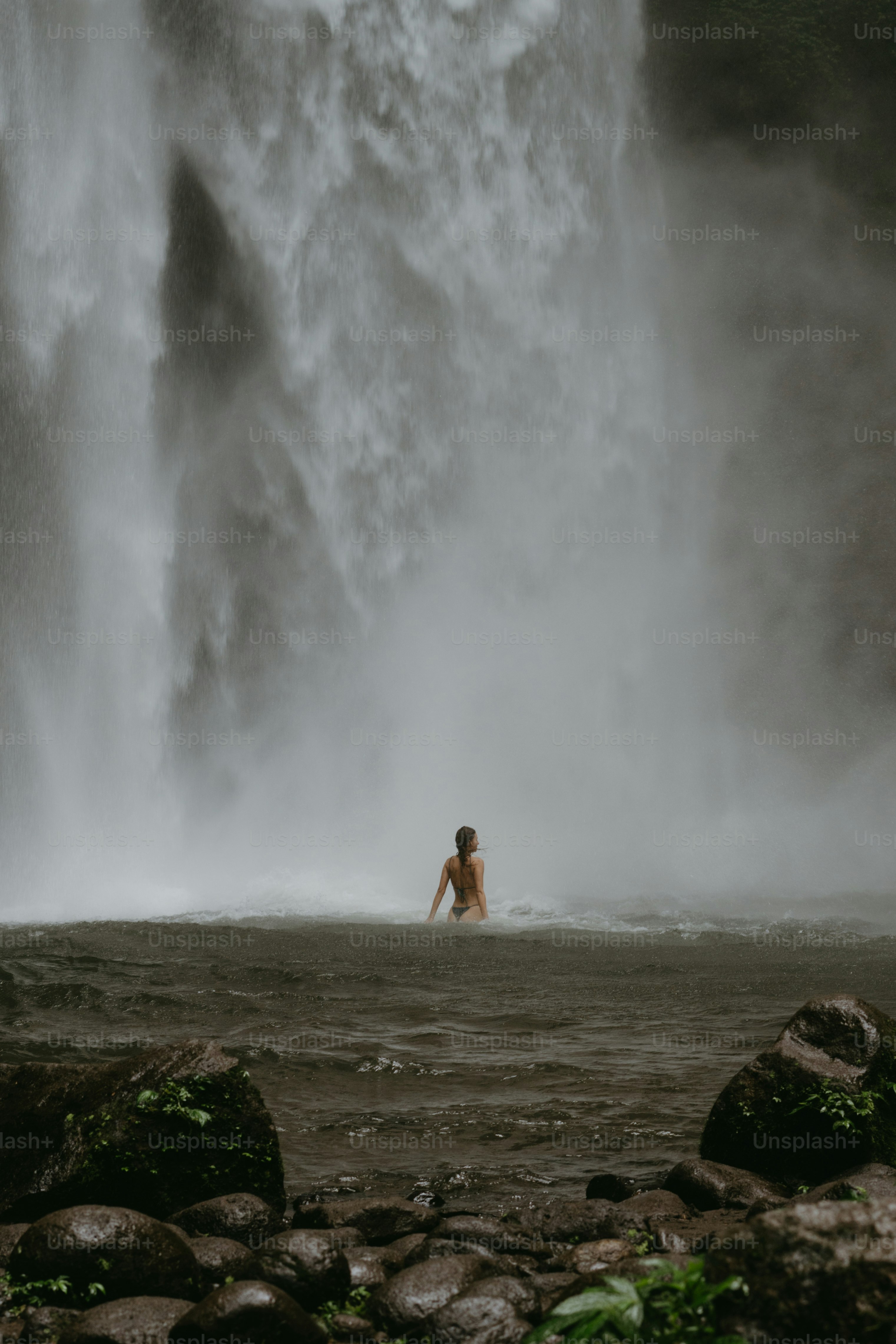 A person standing in front of a waterfall