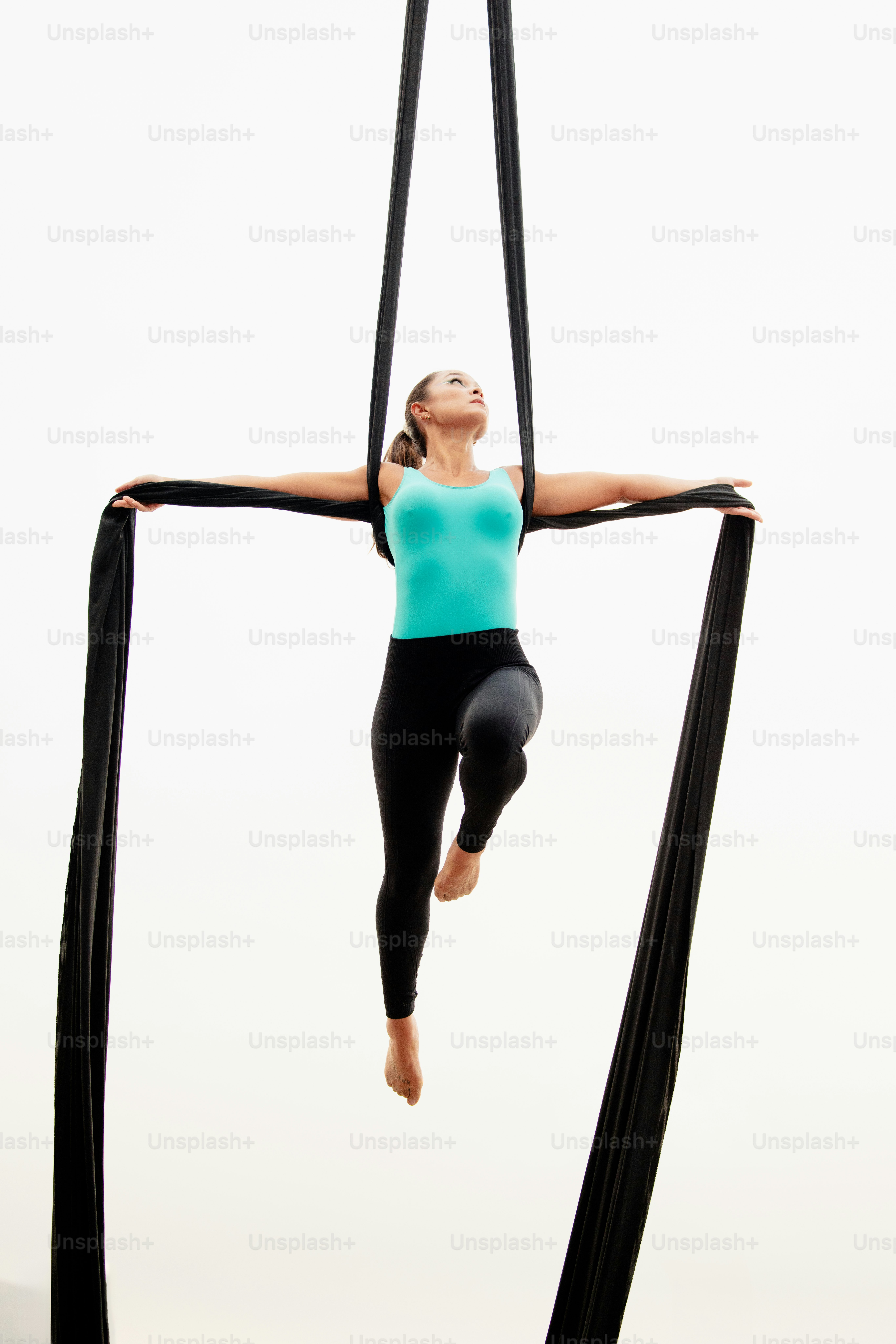 A woman doing aerial acrobatics on a pole