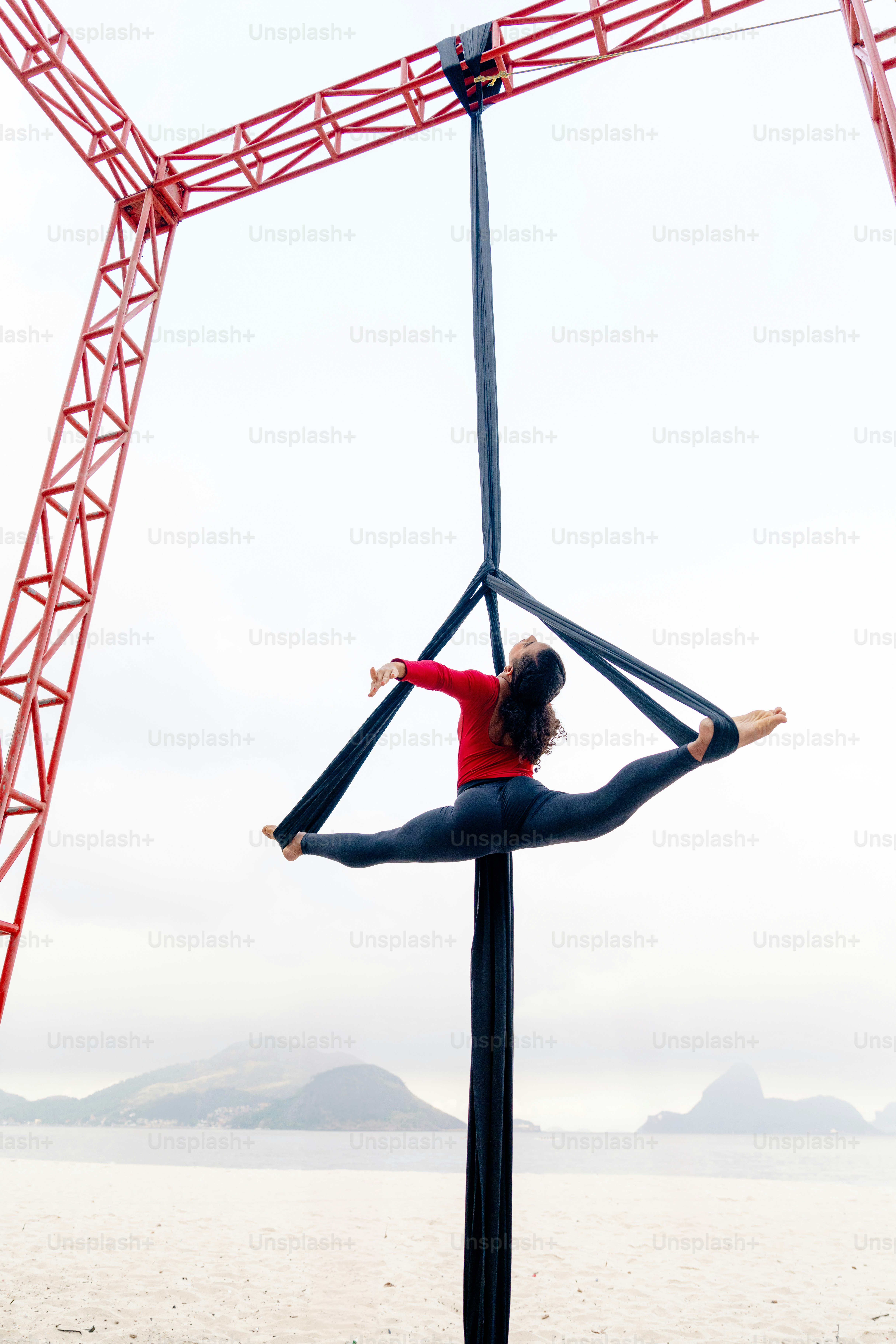 A woman standing on a pole in front of a crane