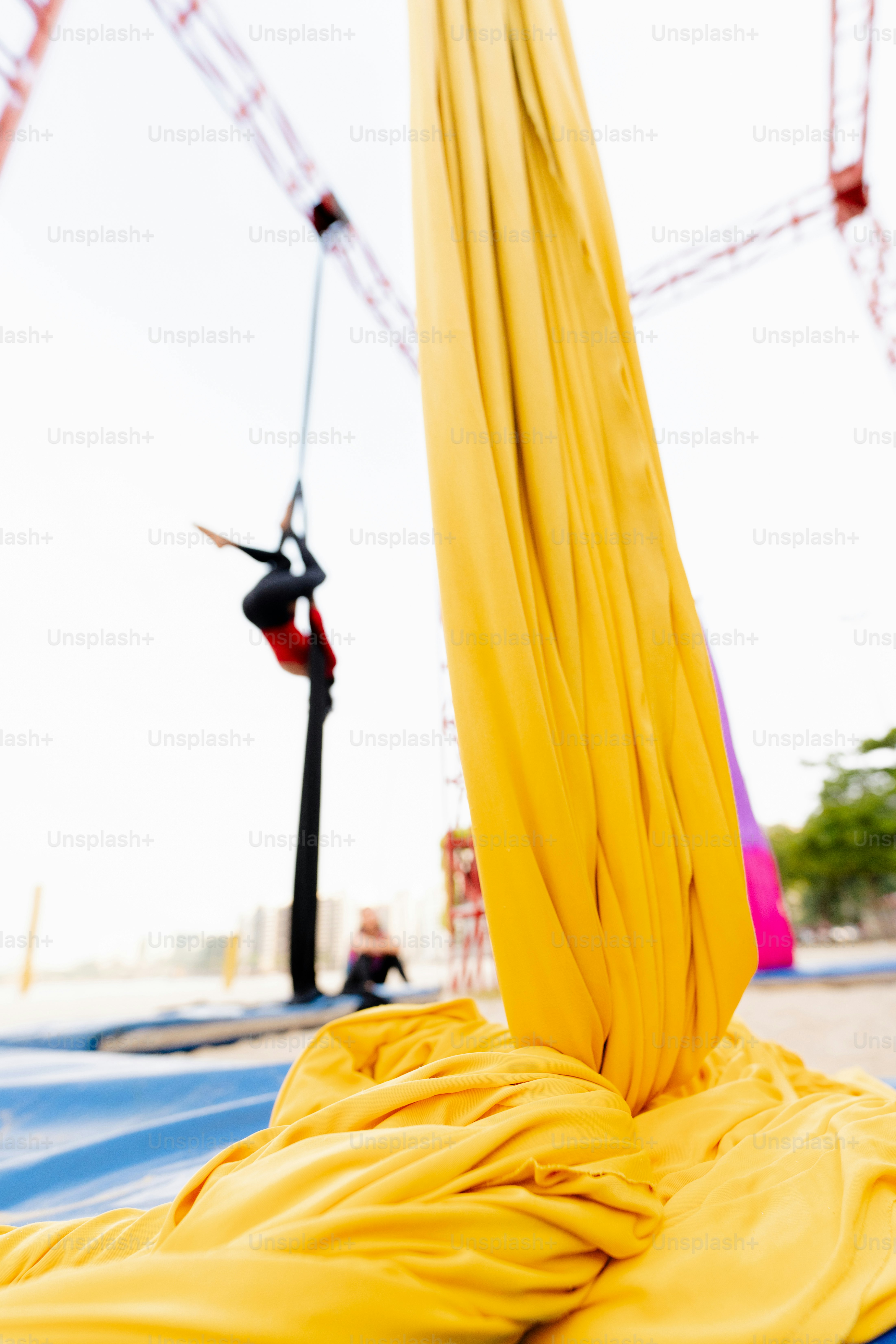 A yellow umbrella laying on top of a blue tarp