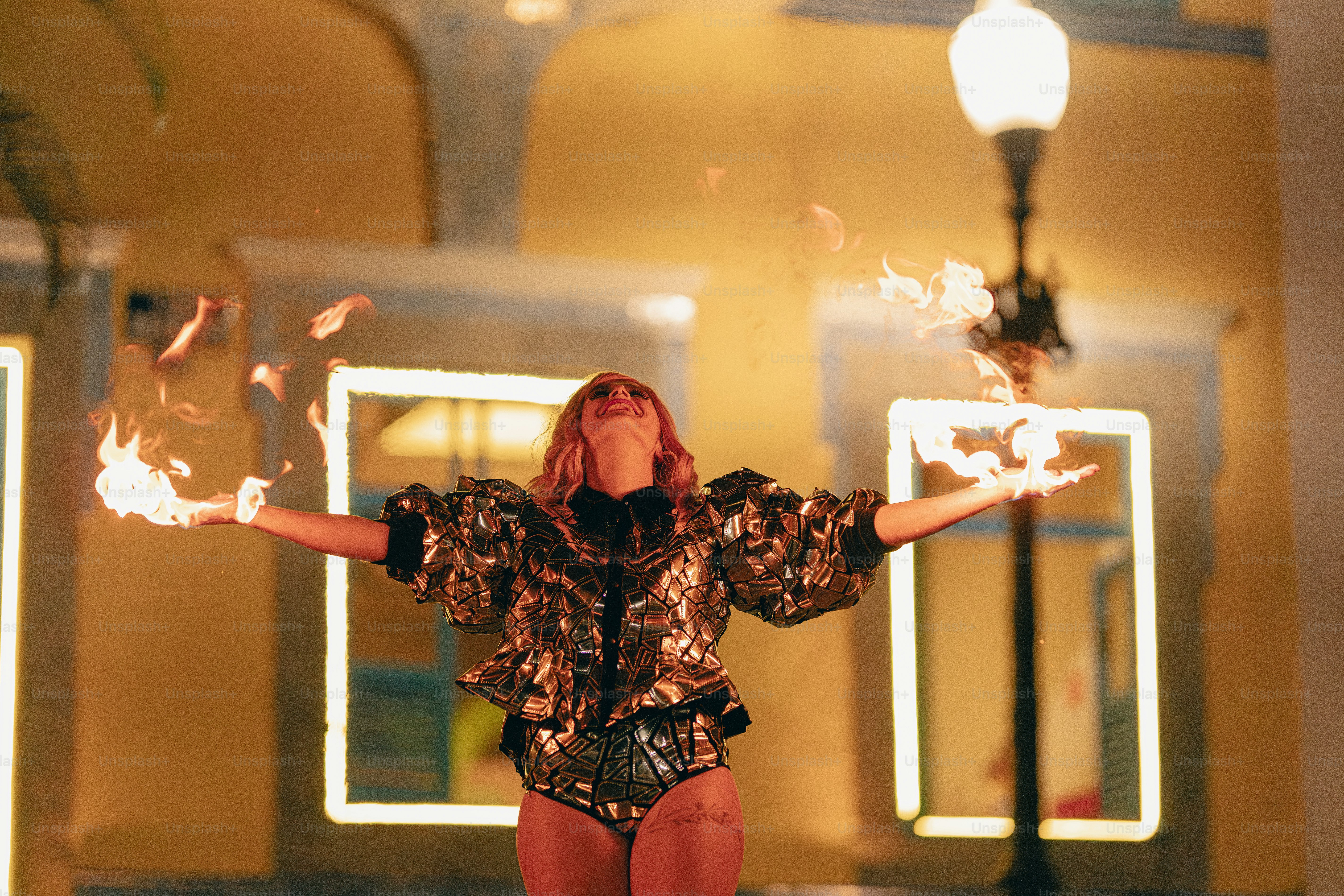 A woman standing in front of a building holding fire