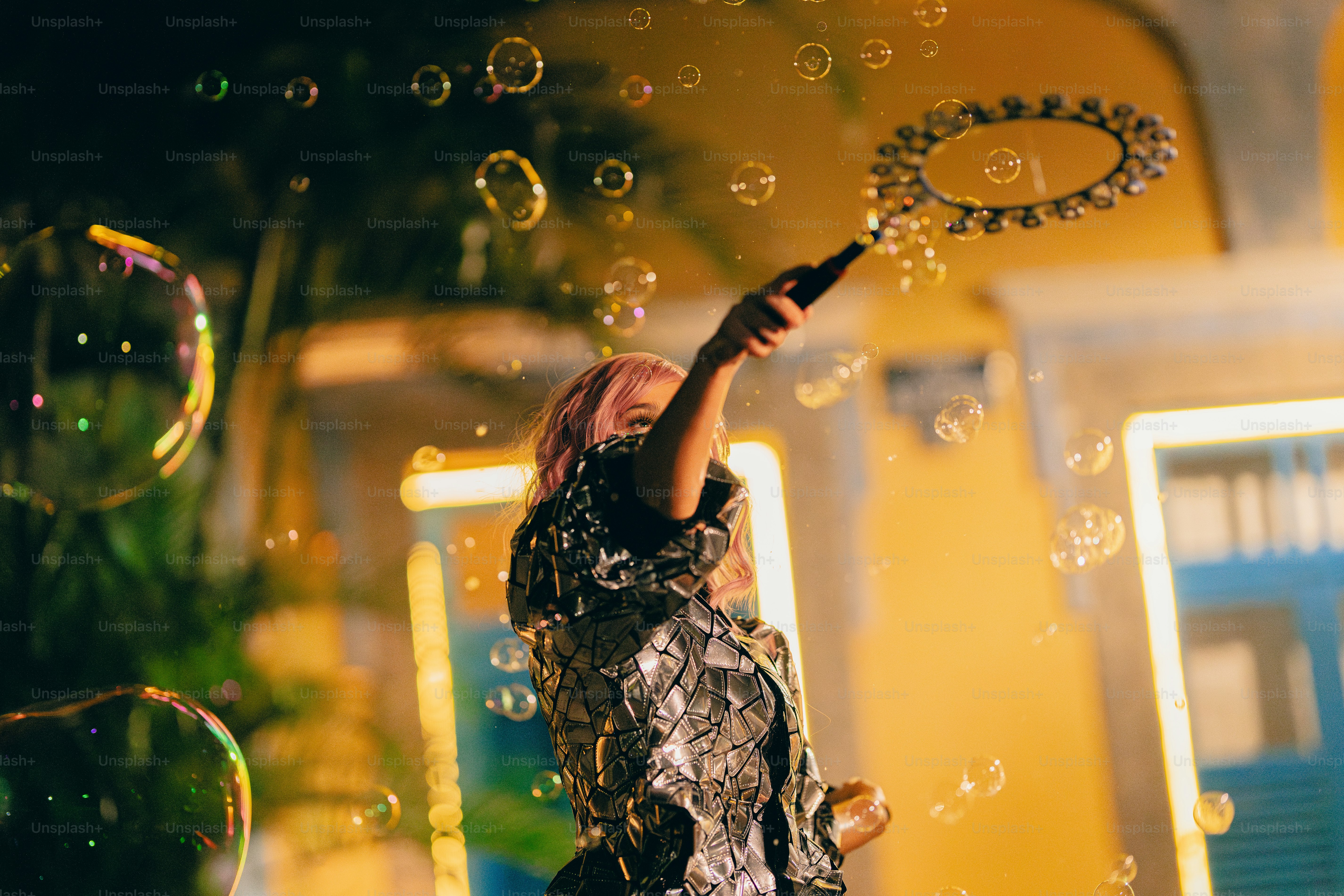 A woman standing in front of a building with bubbles in the air