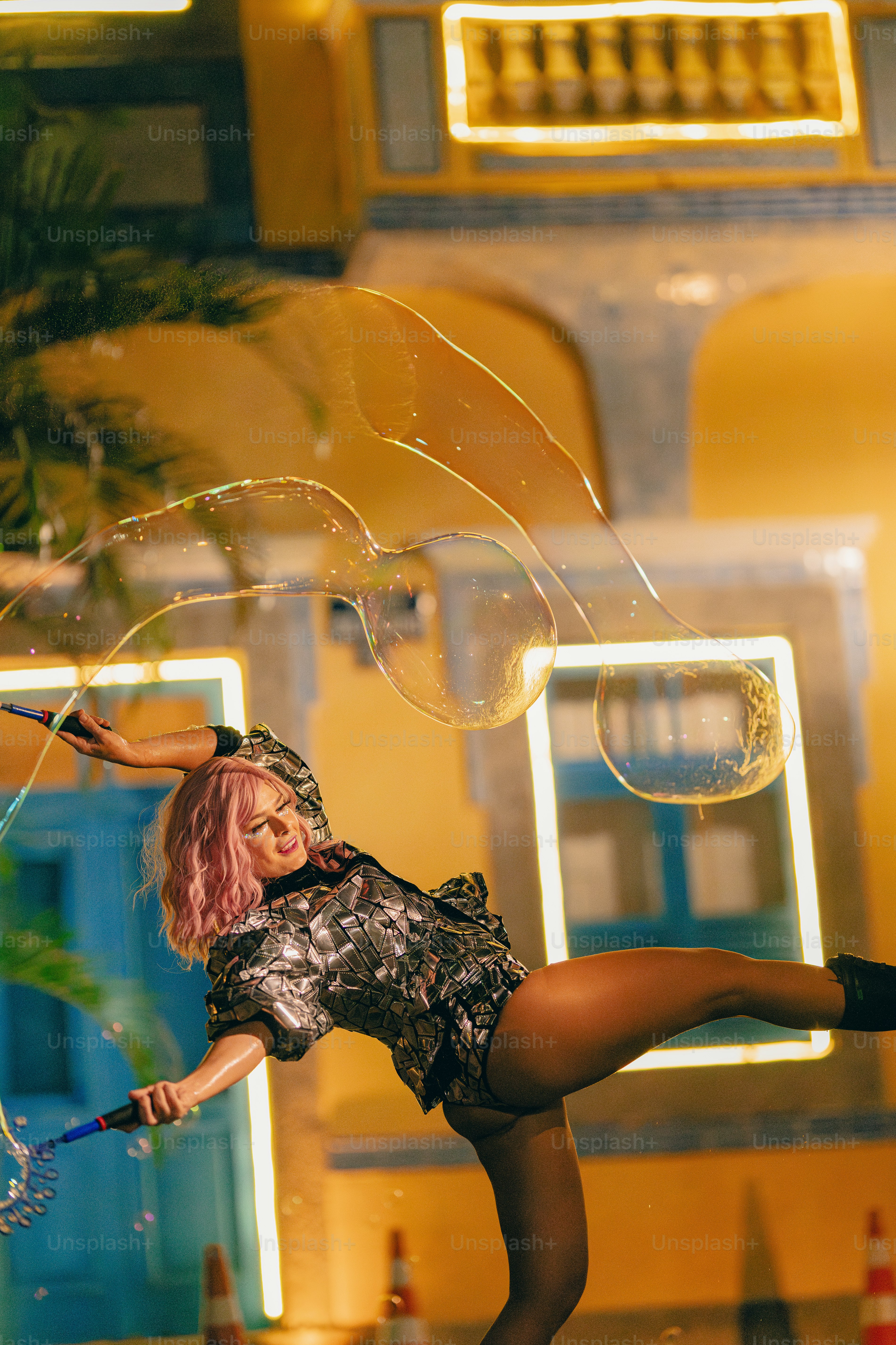 A woman in a short dress is playing with bubbles