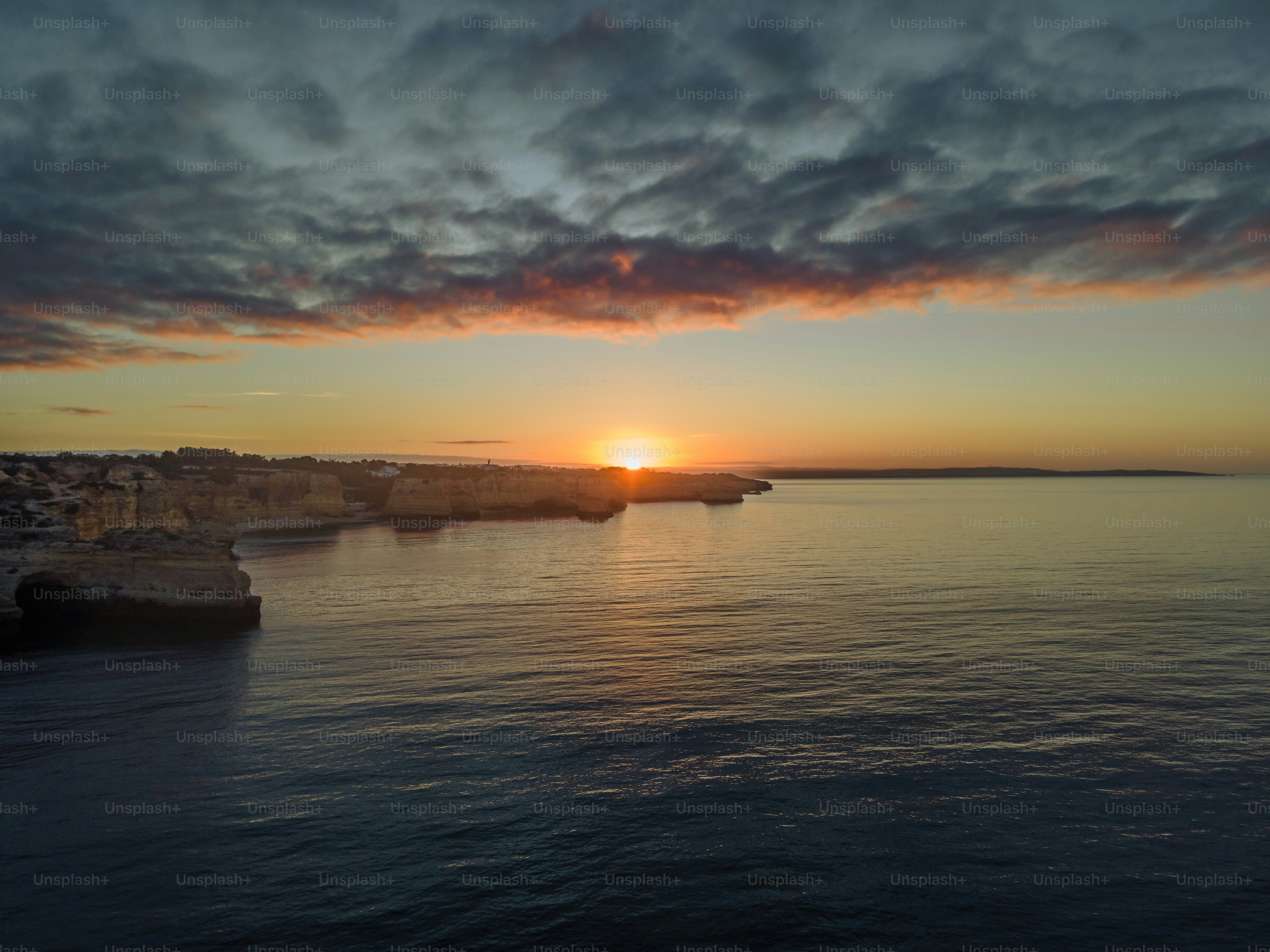 A sunset over a body of water with a city in the background