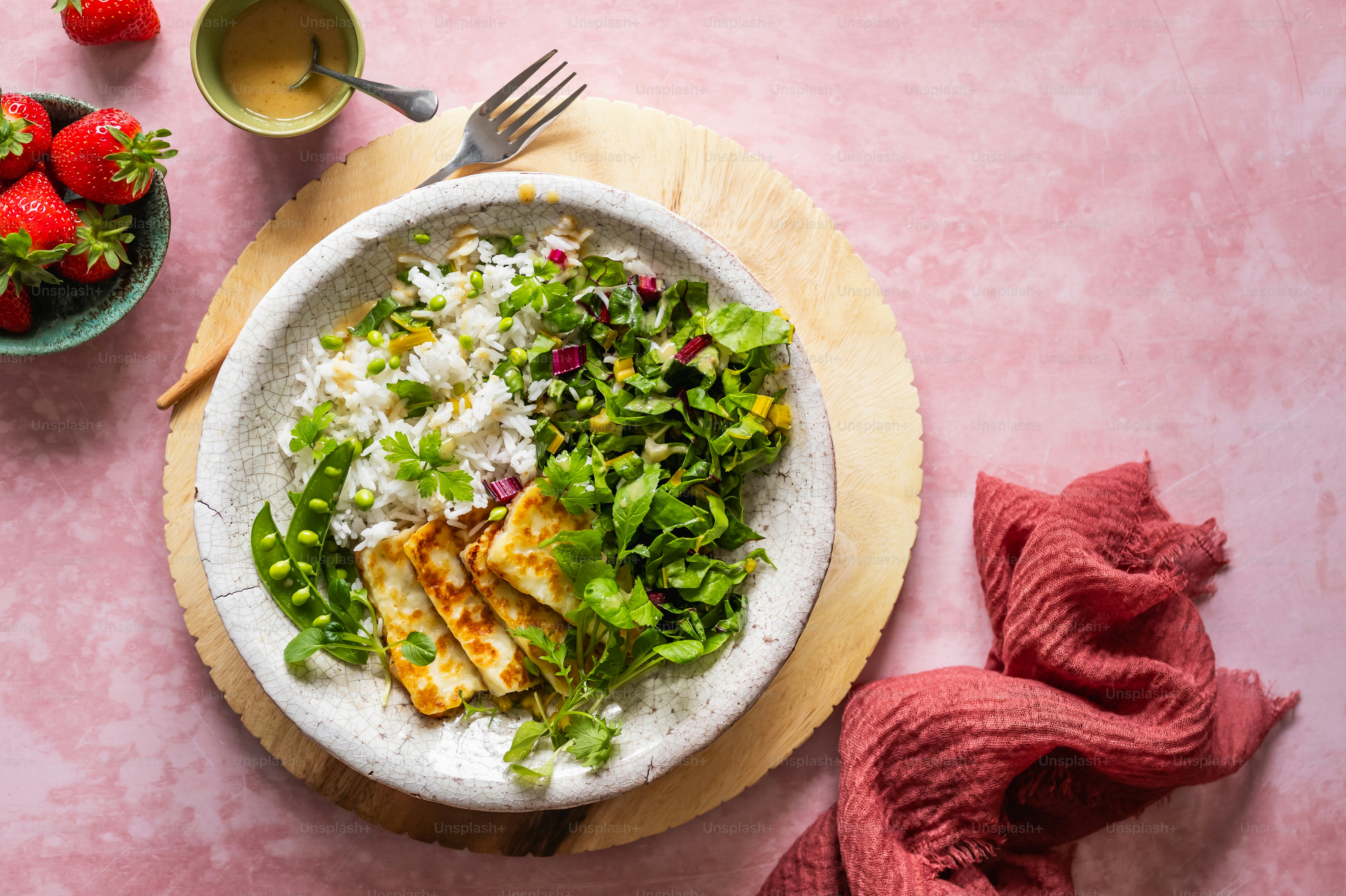 A plate of food on a table with a bowl of strawberries