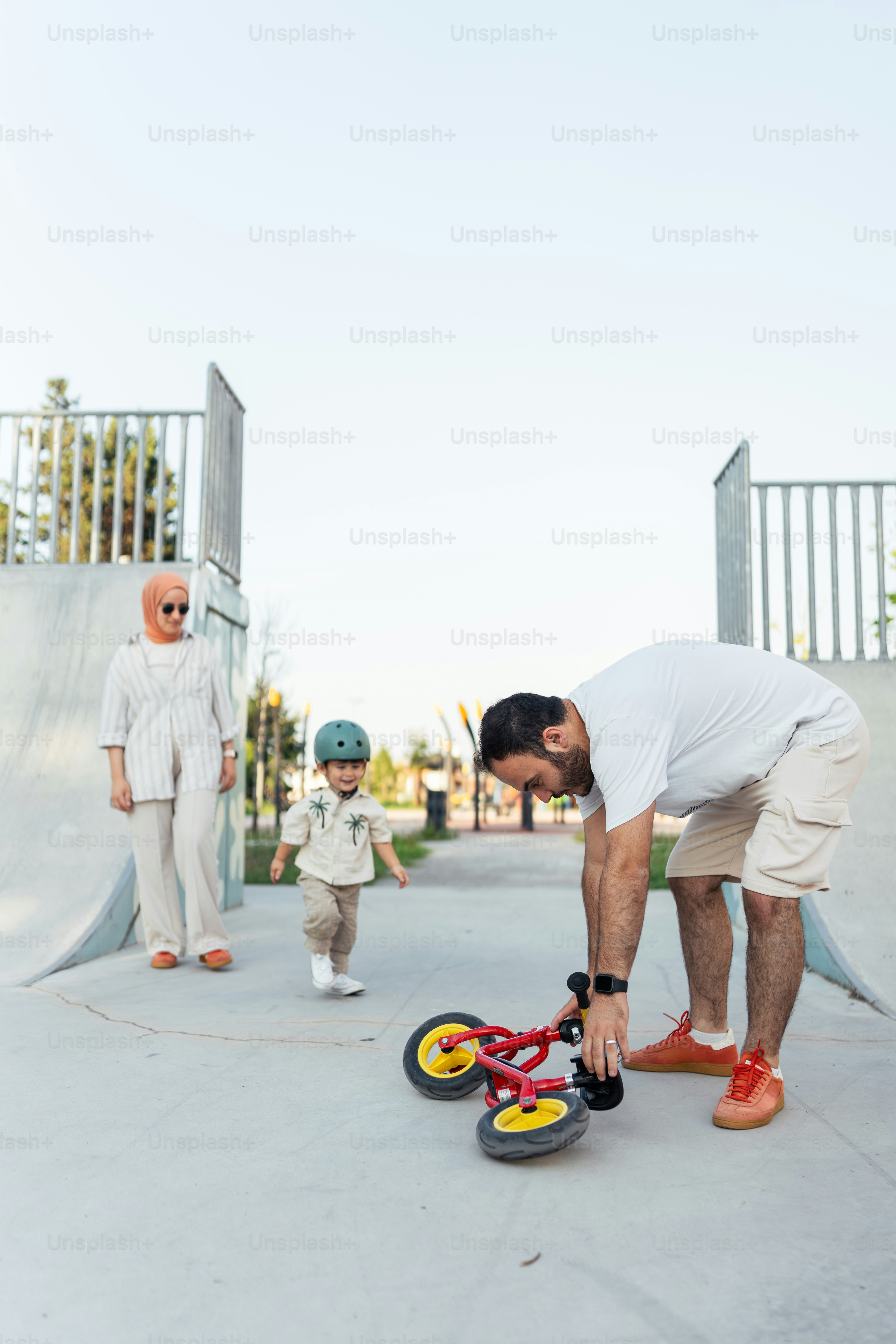 A man bending over on a skateboard in a skate park