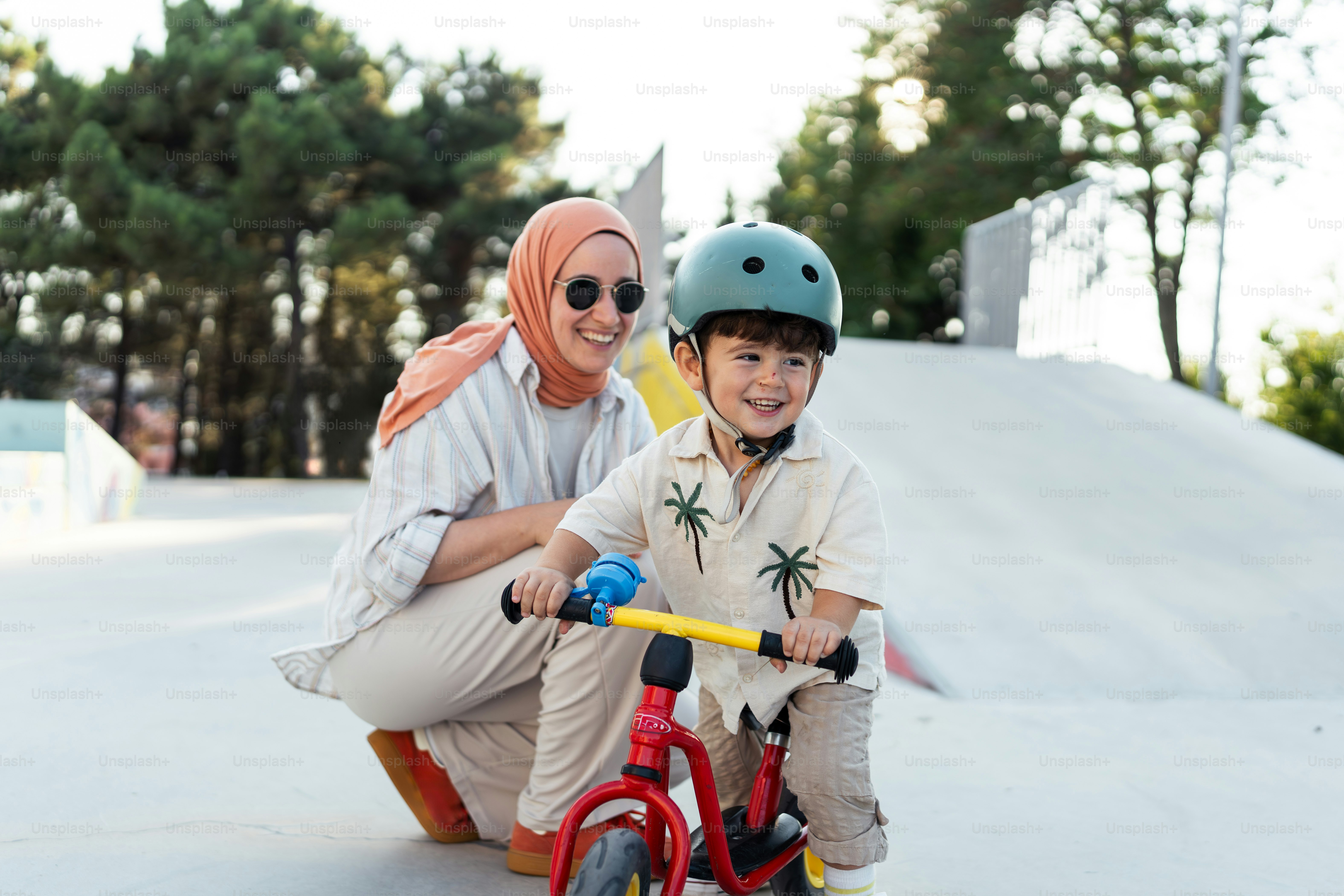 A woman and a child on a scooter at a skate park