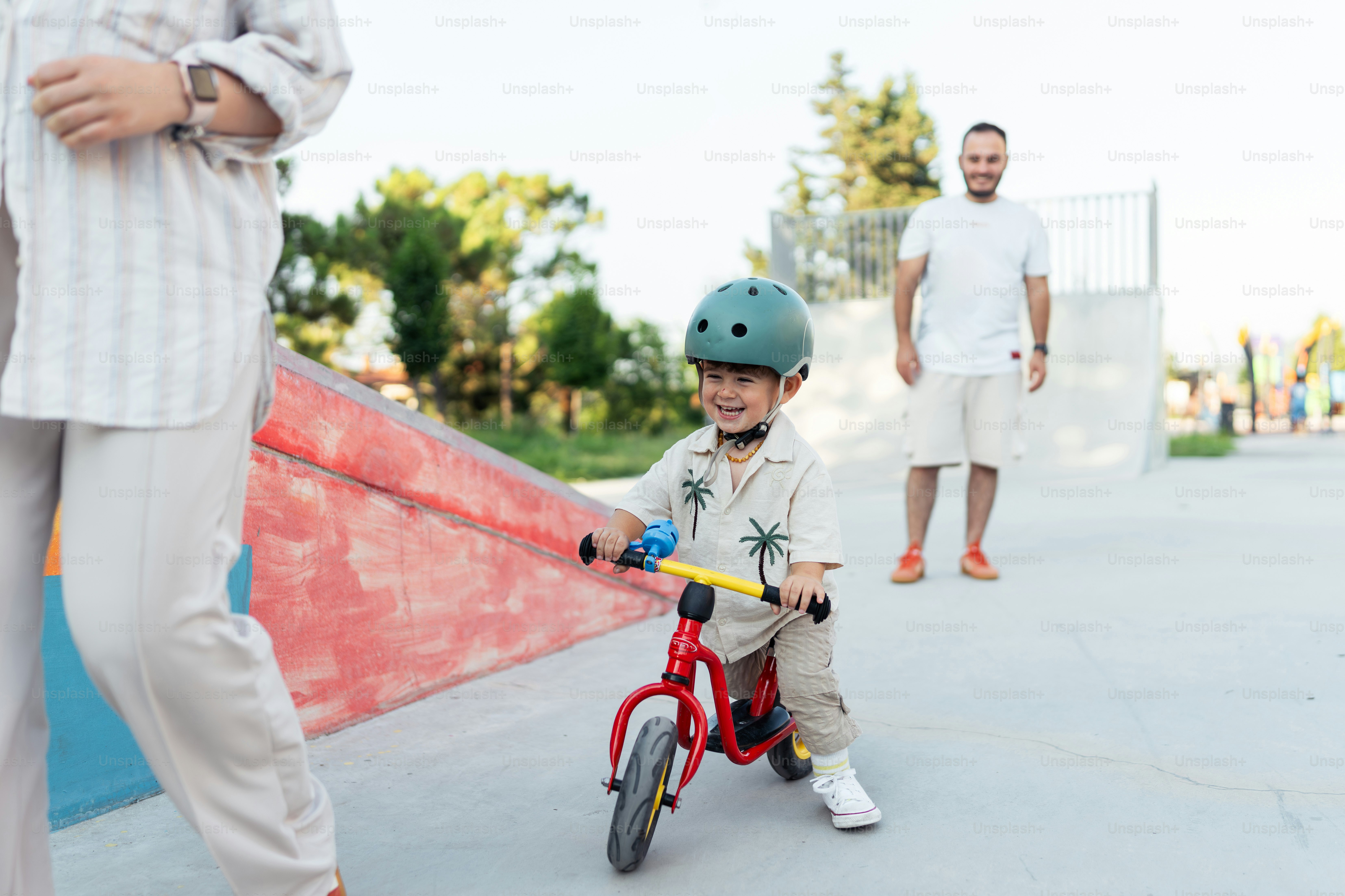 A little boy riding a bike with a helmet on