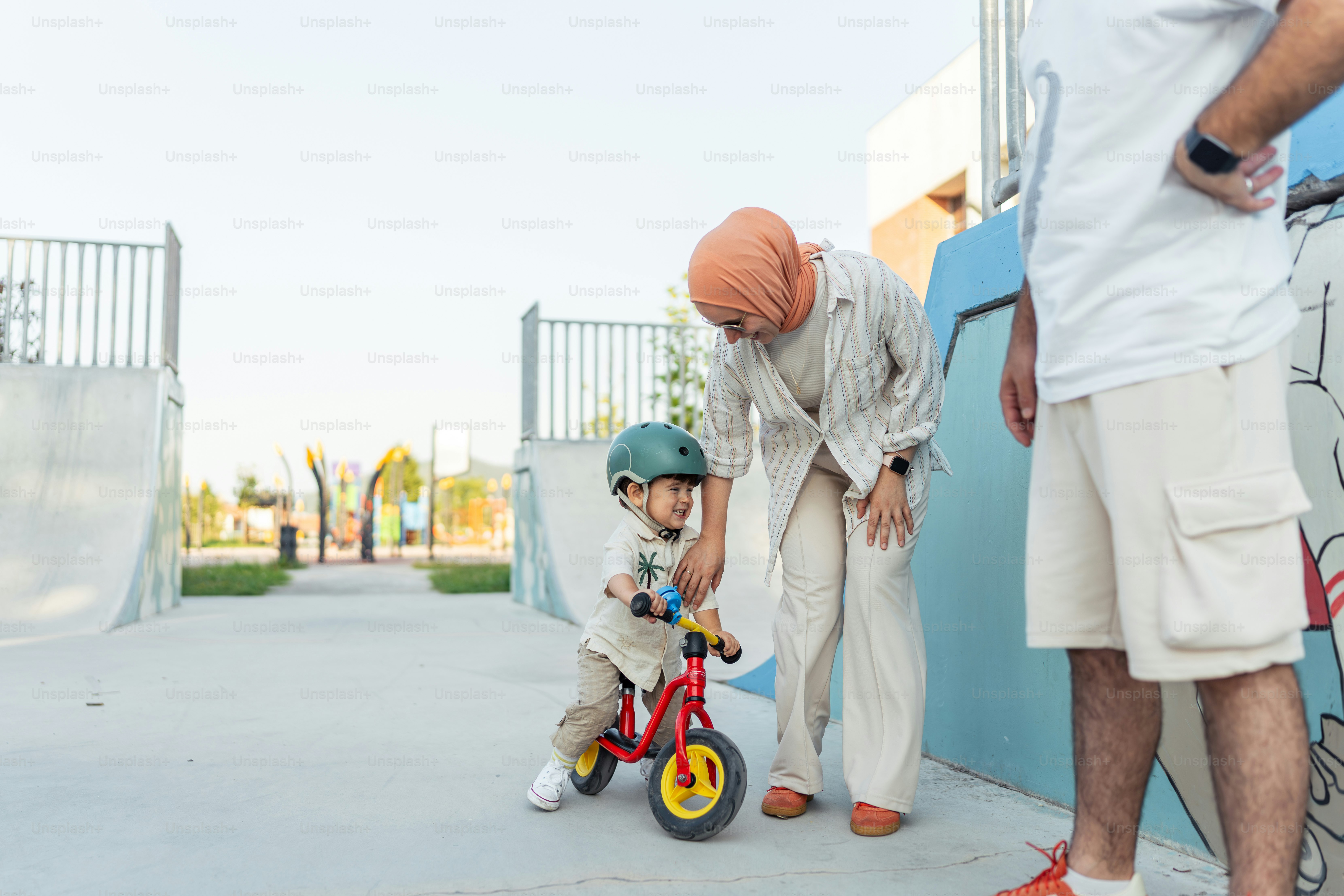 A little boy riding a bike next to a man