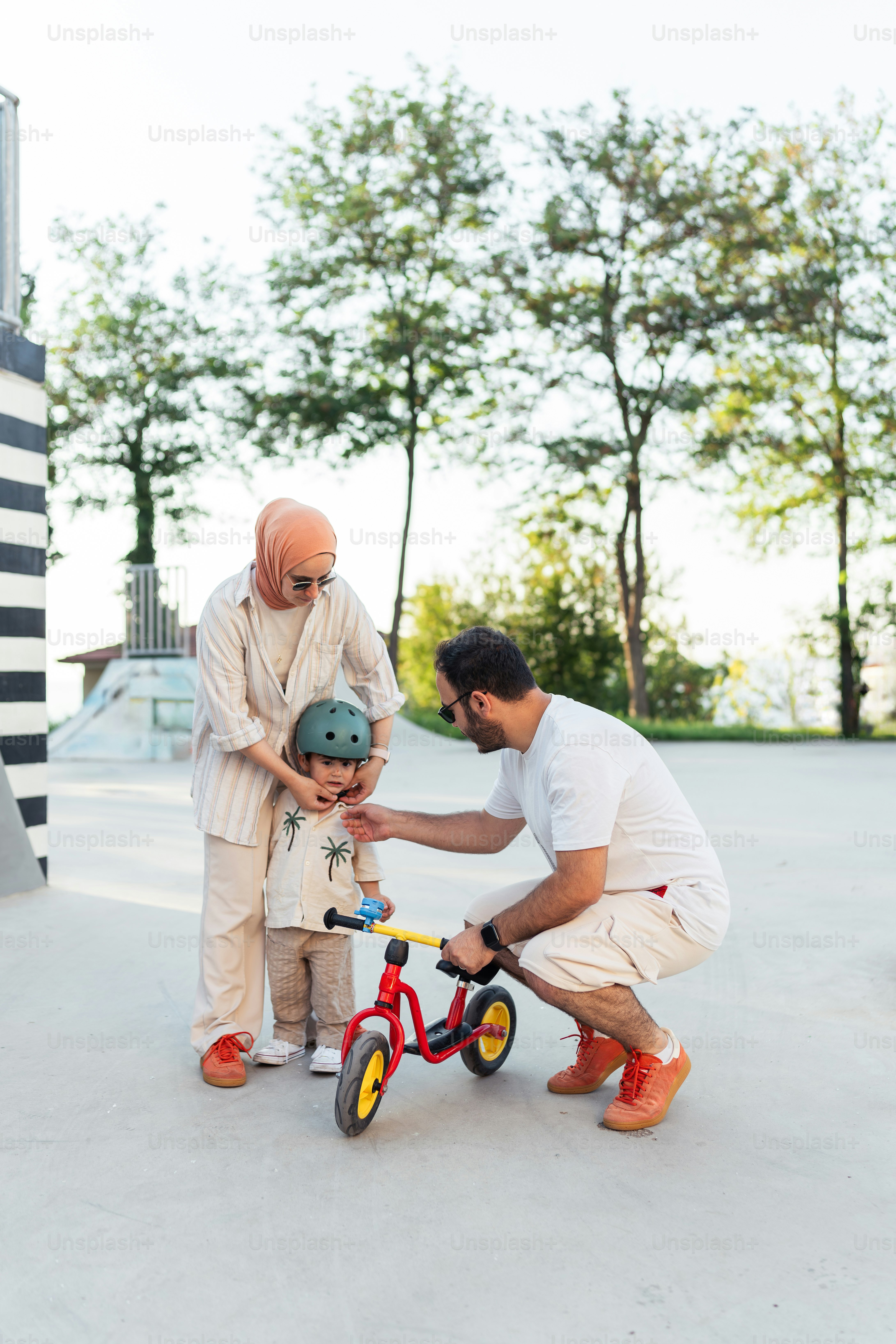 A man helping a little boy ride a bike