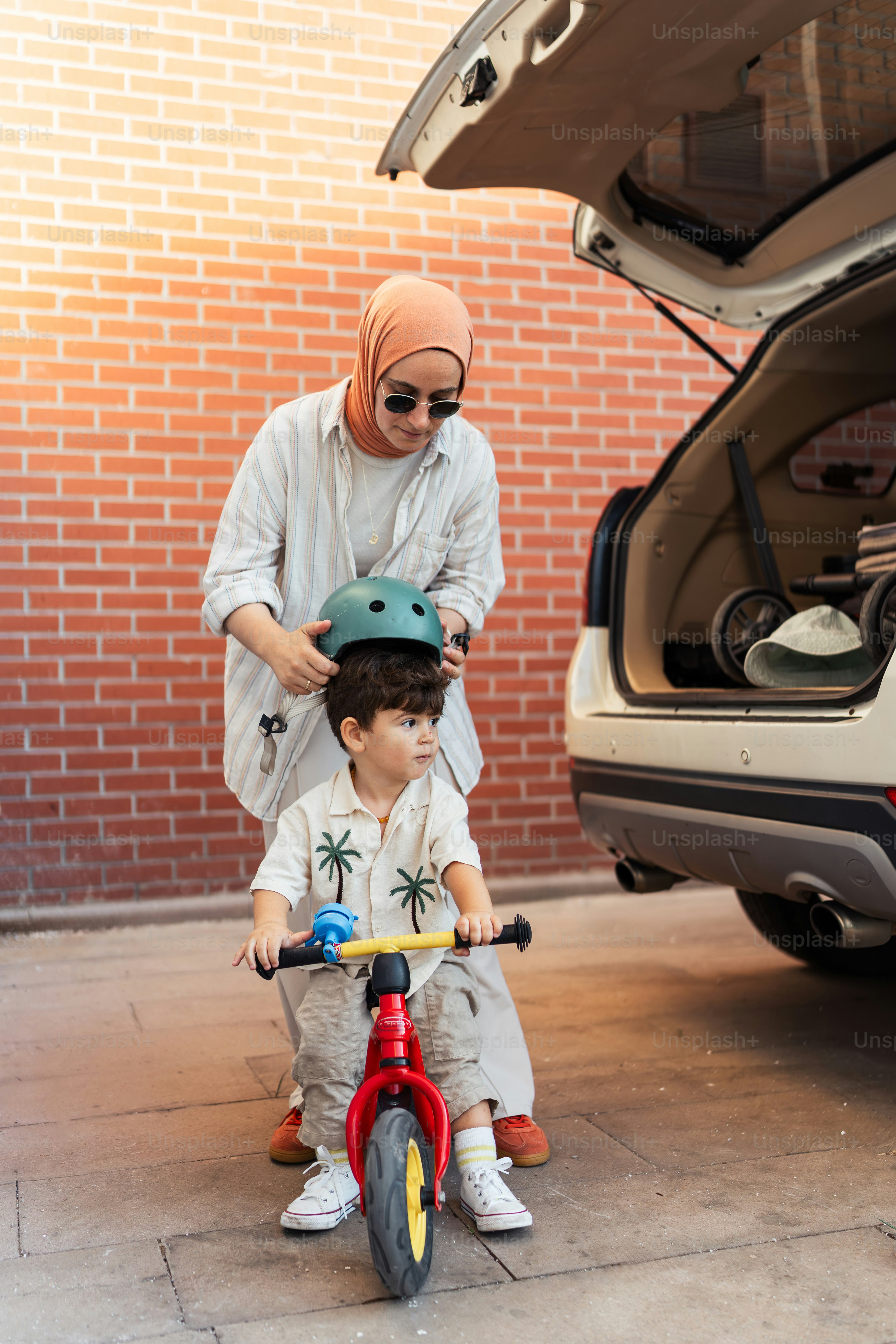 A woman standing next to a child on a bike