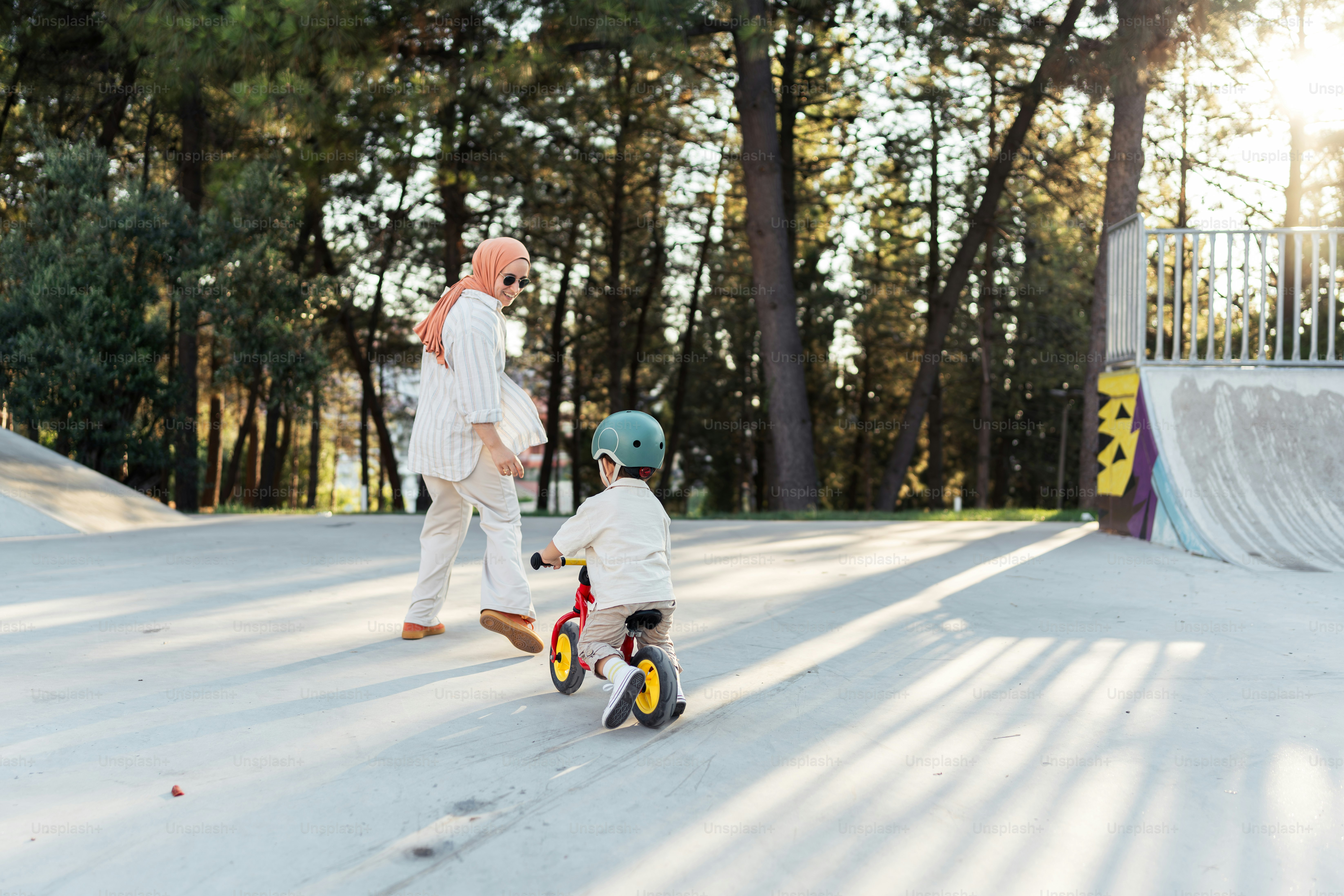 A man and a small child riding on a skateboard