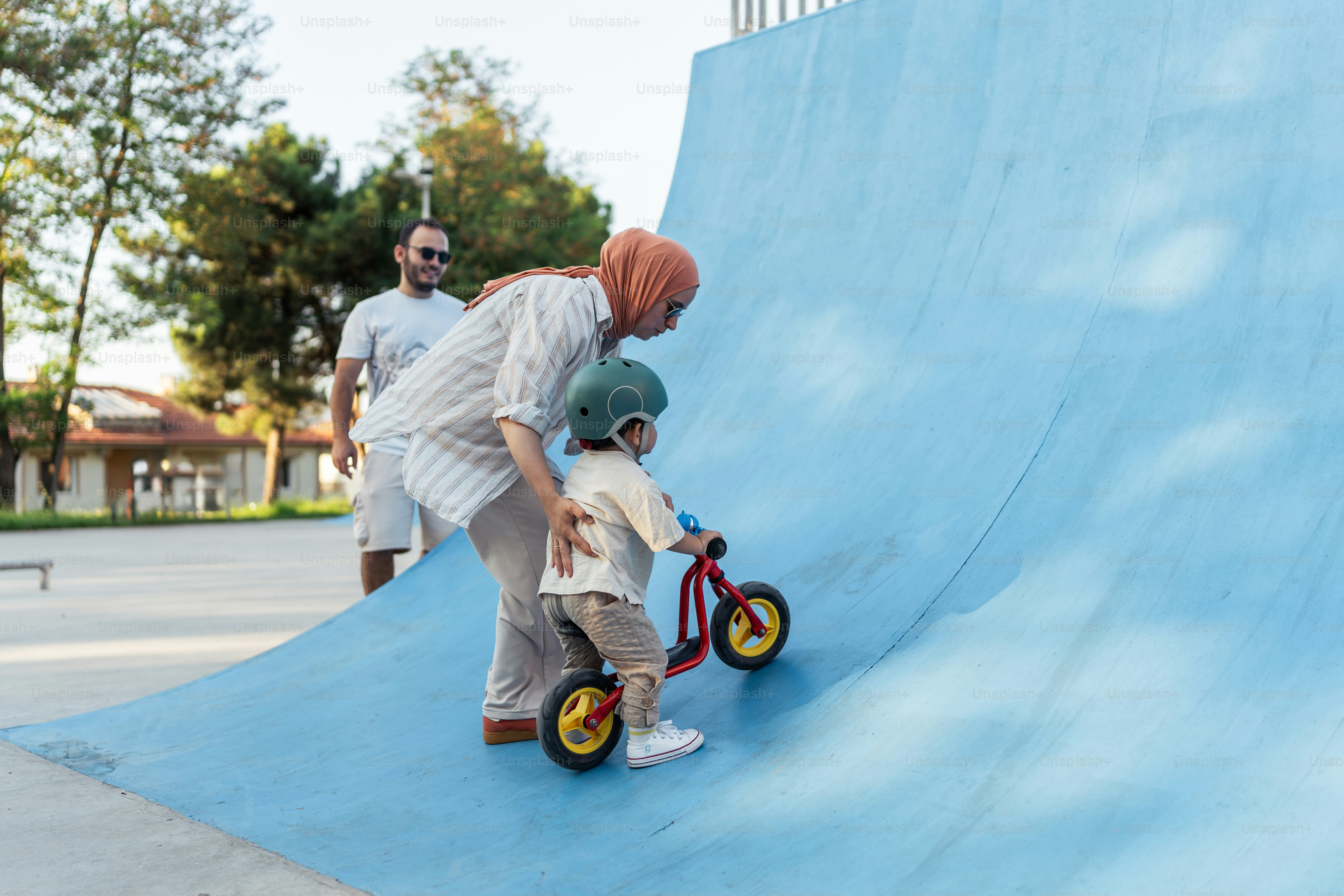 A young boy riding a bike down a blue ramp photo – Family Image on Unsplash