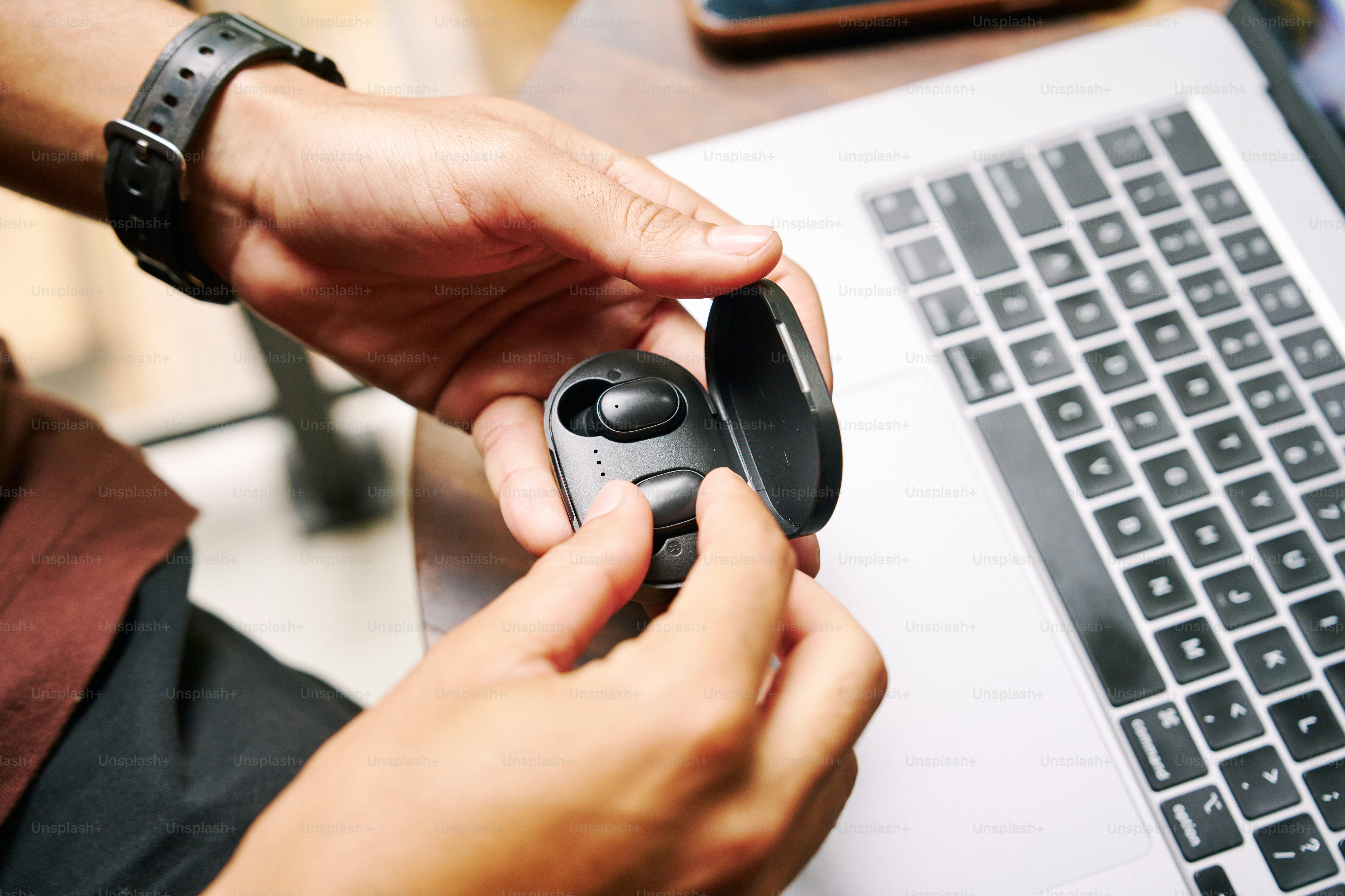 Una persona che tiene un mouse davanti a un laptop