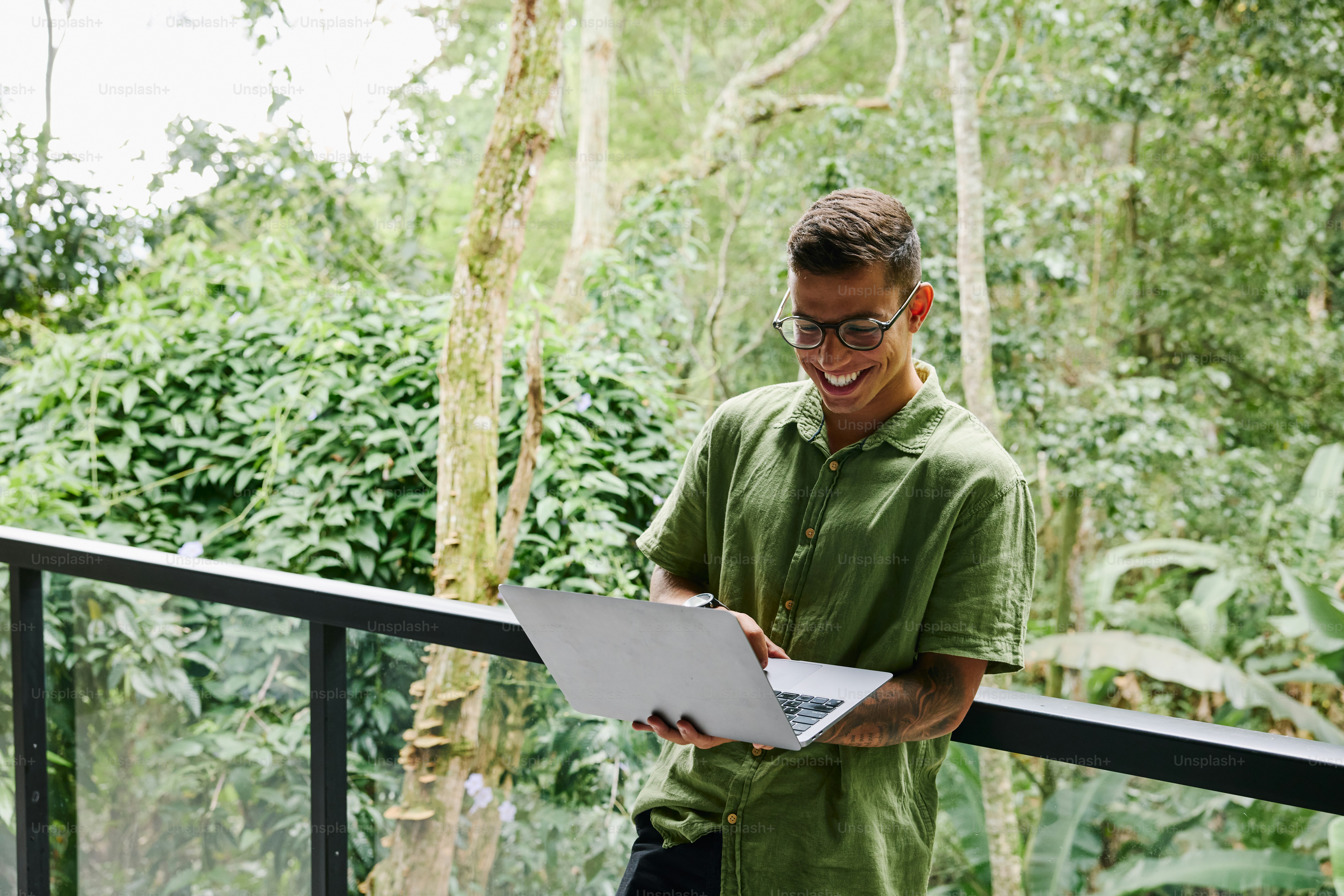 A man standing on a balcony holding a piece of paper