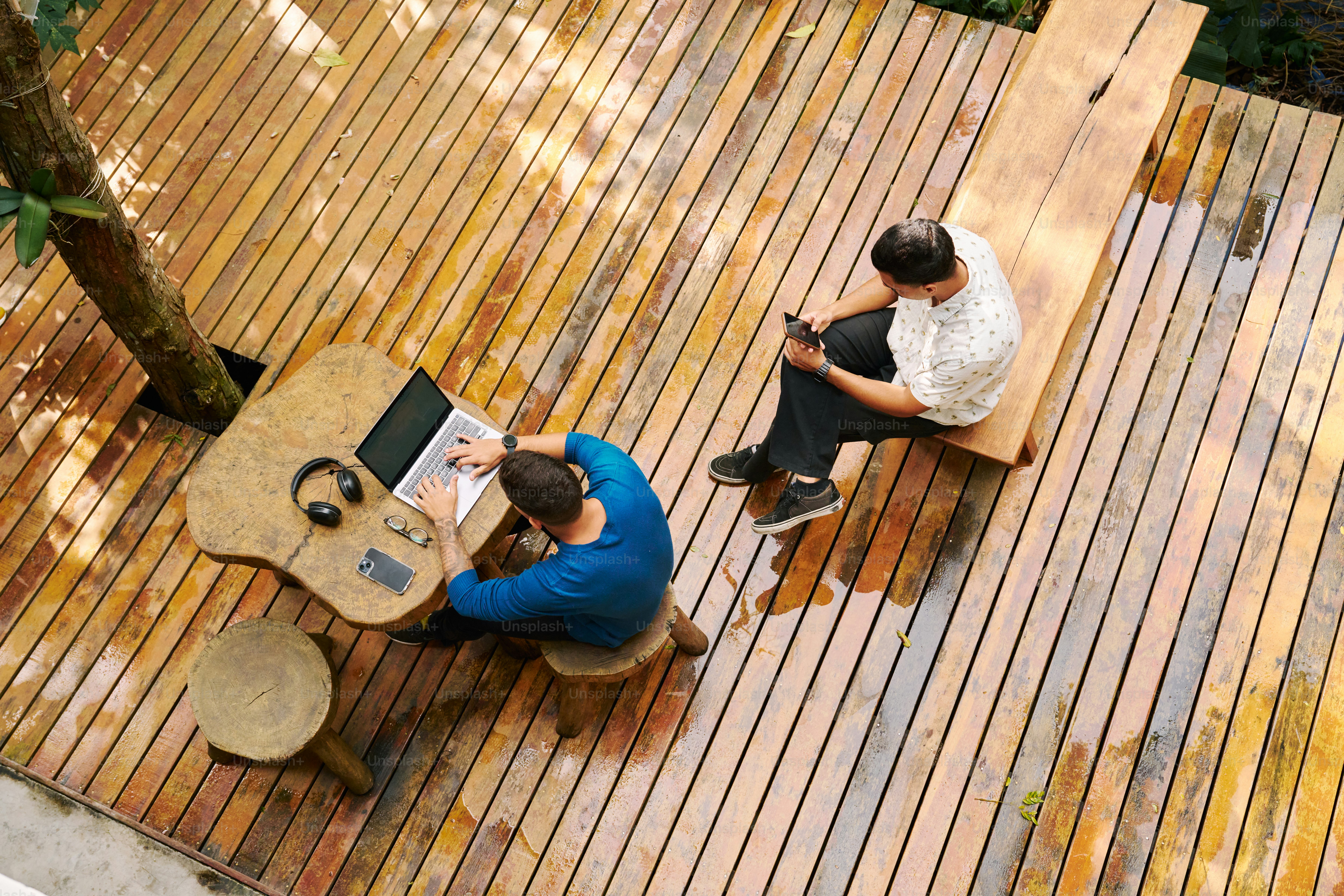 A couple of people sitting on top of a wooden deck