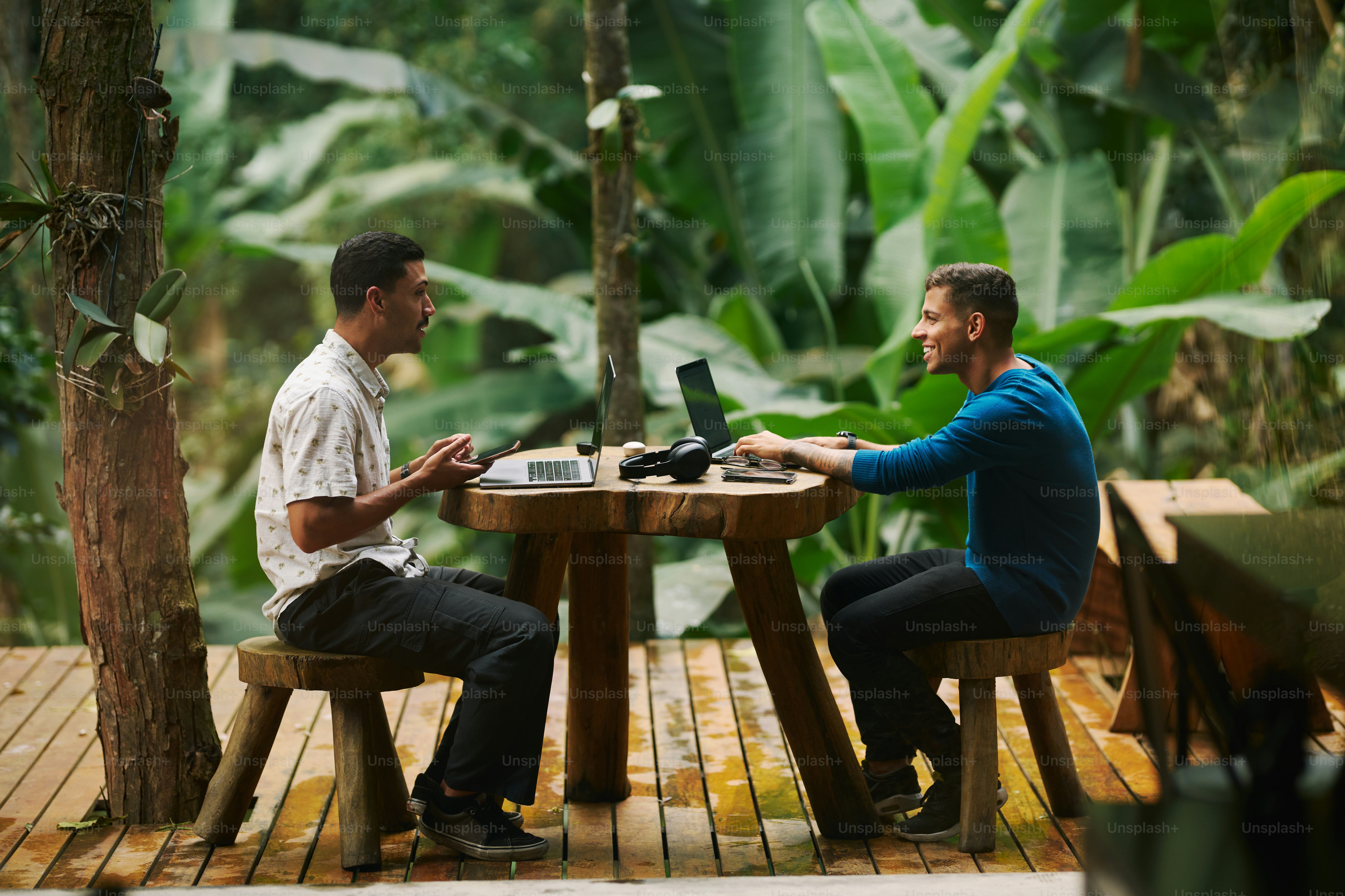 A couple of men sitting at a wooden table