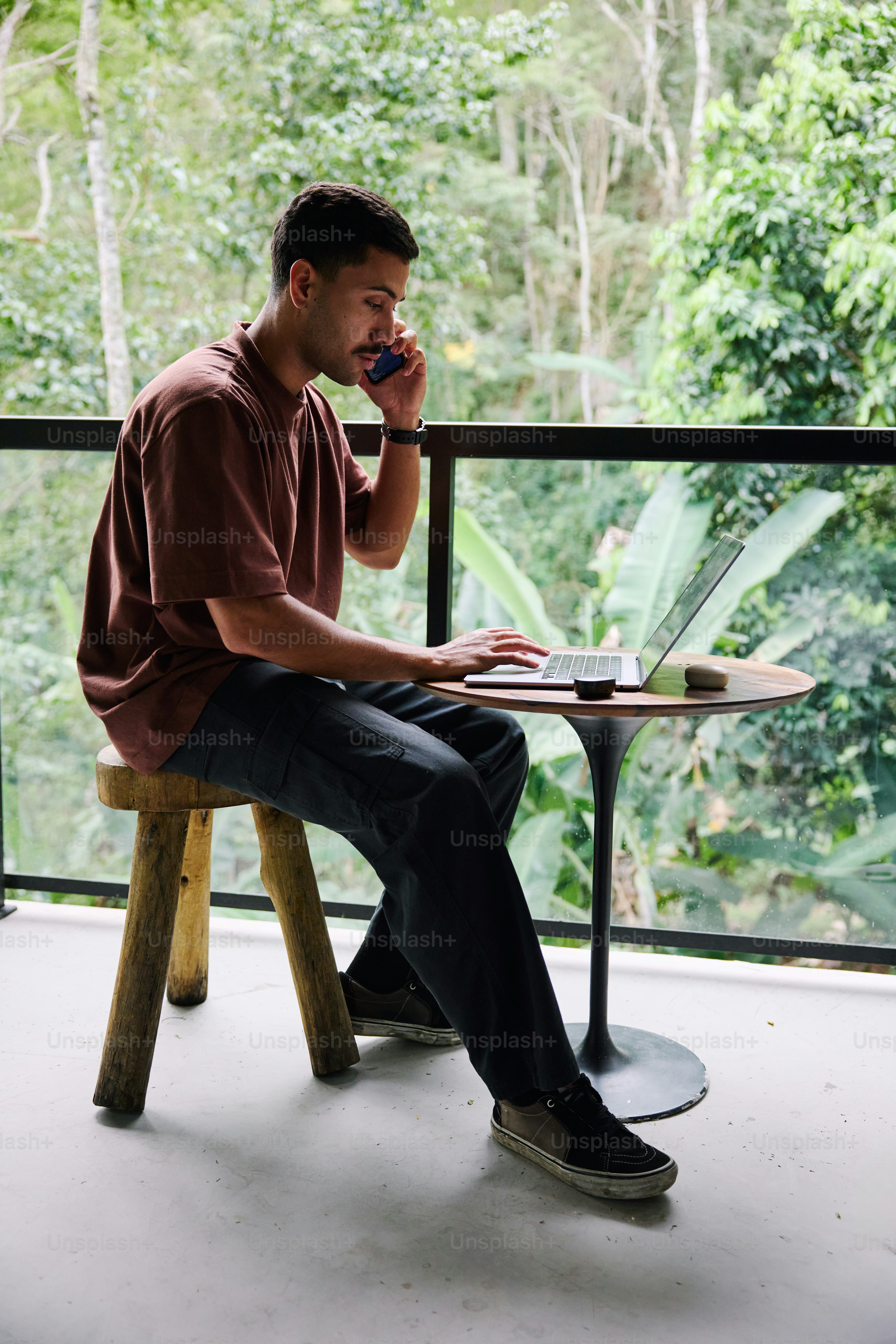 A man sitting at a table on a cell phone