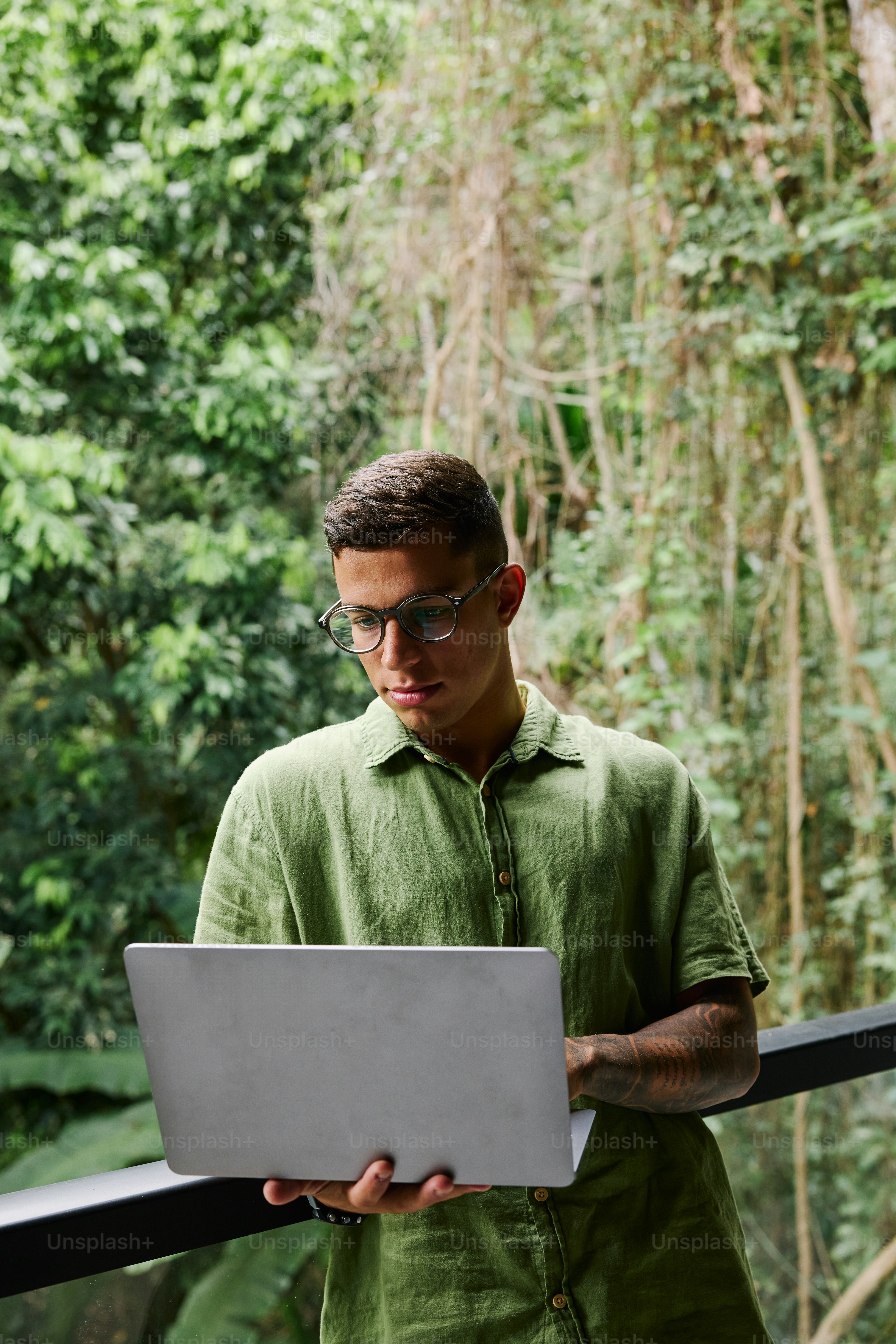 A man in a green shirt using a laptop computer