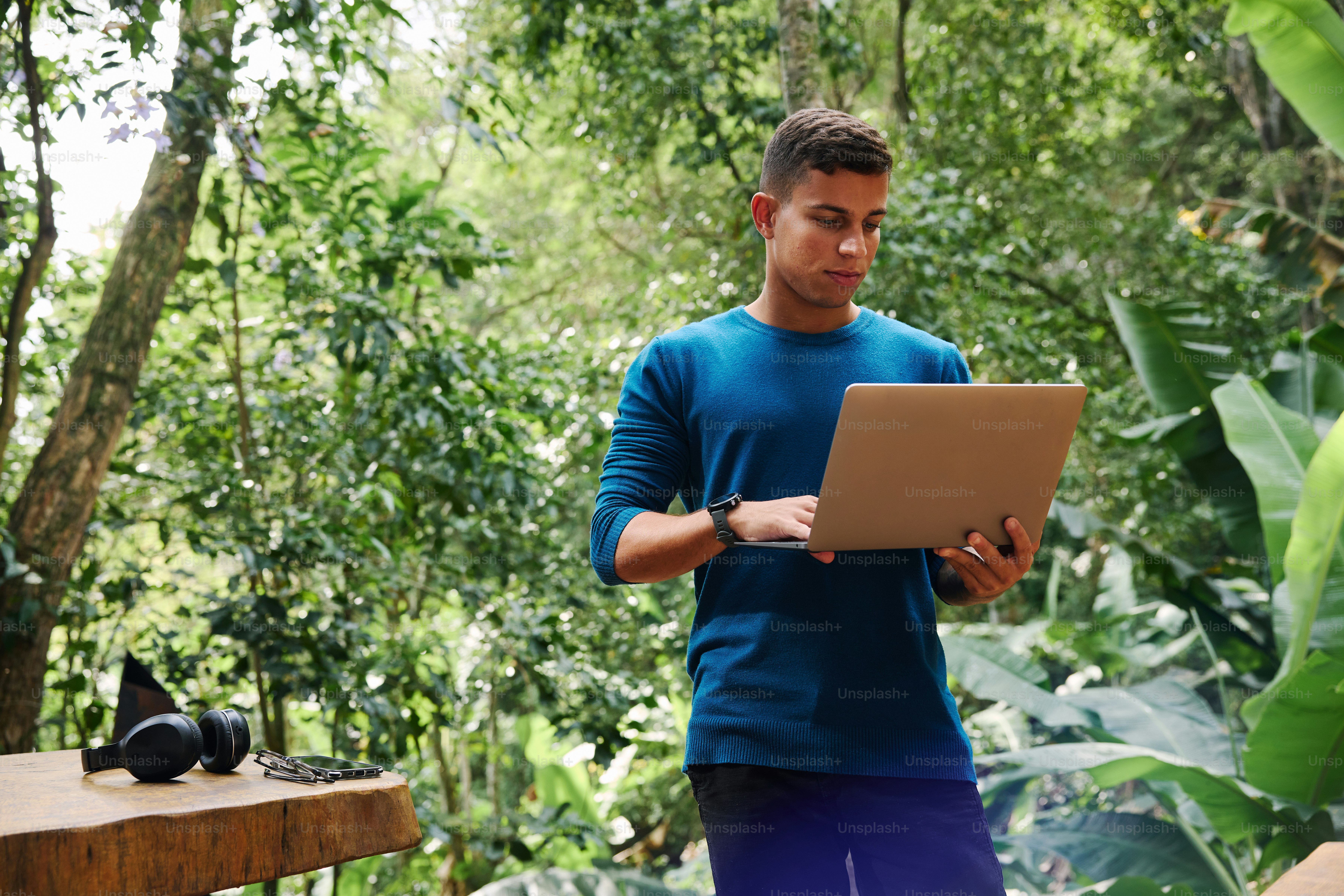 A man in blue shirt using a laptop computer