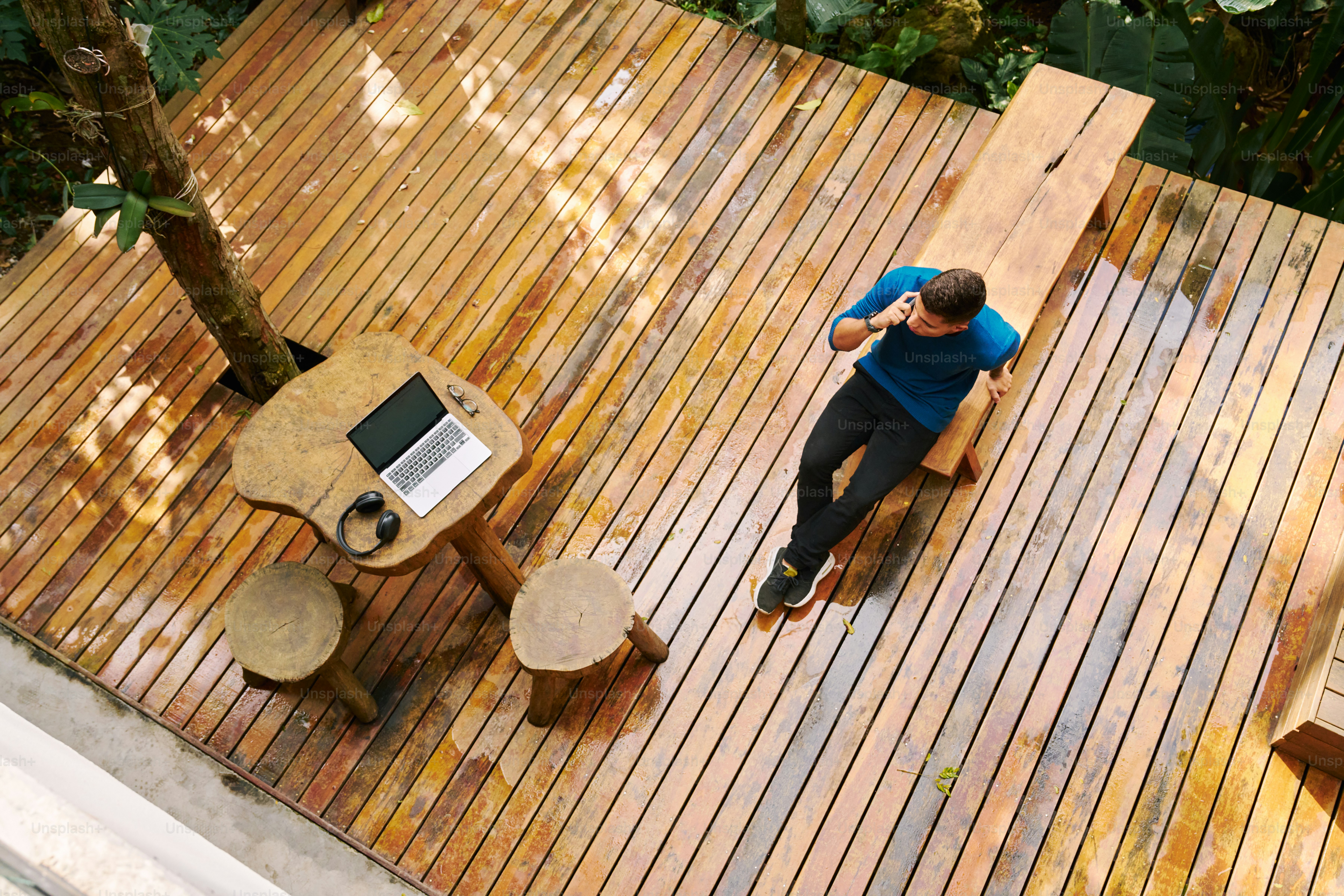 A man sitting at a table on top of a wooden deck