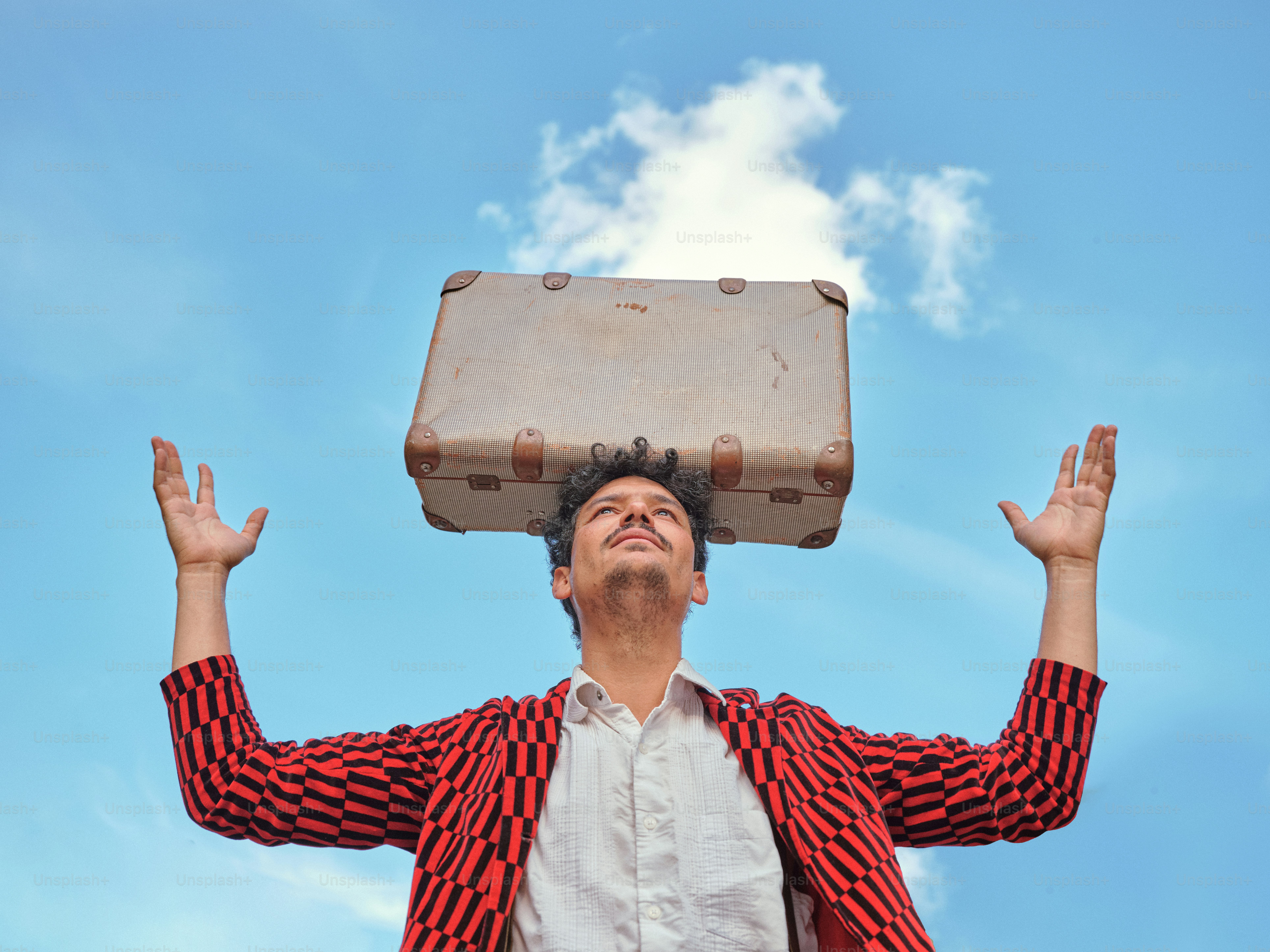 Ein Mann mit einem Koffer auf dem Kopf