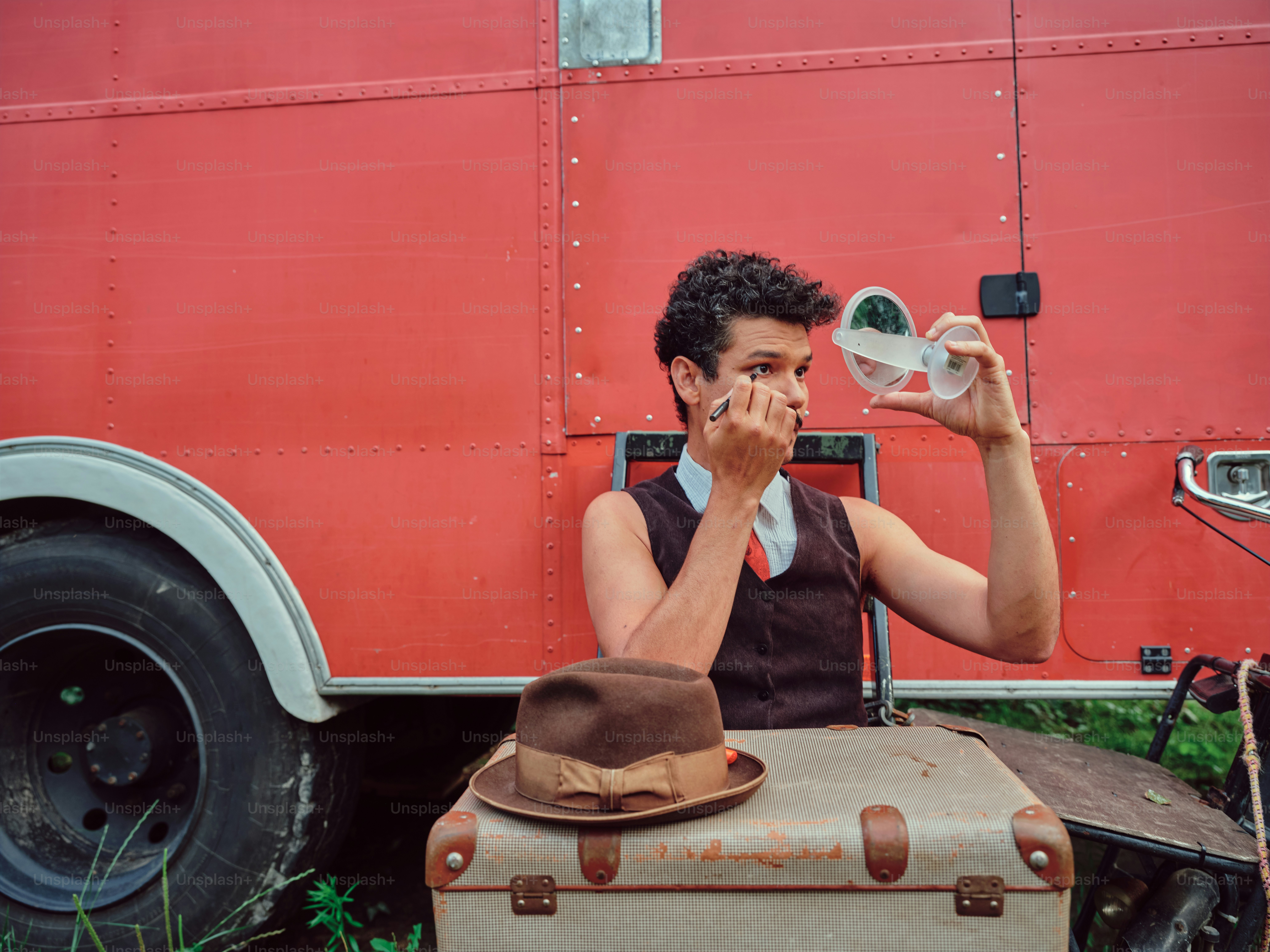 Ein Mann sitzt auf einem Gepäckstück