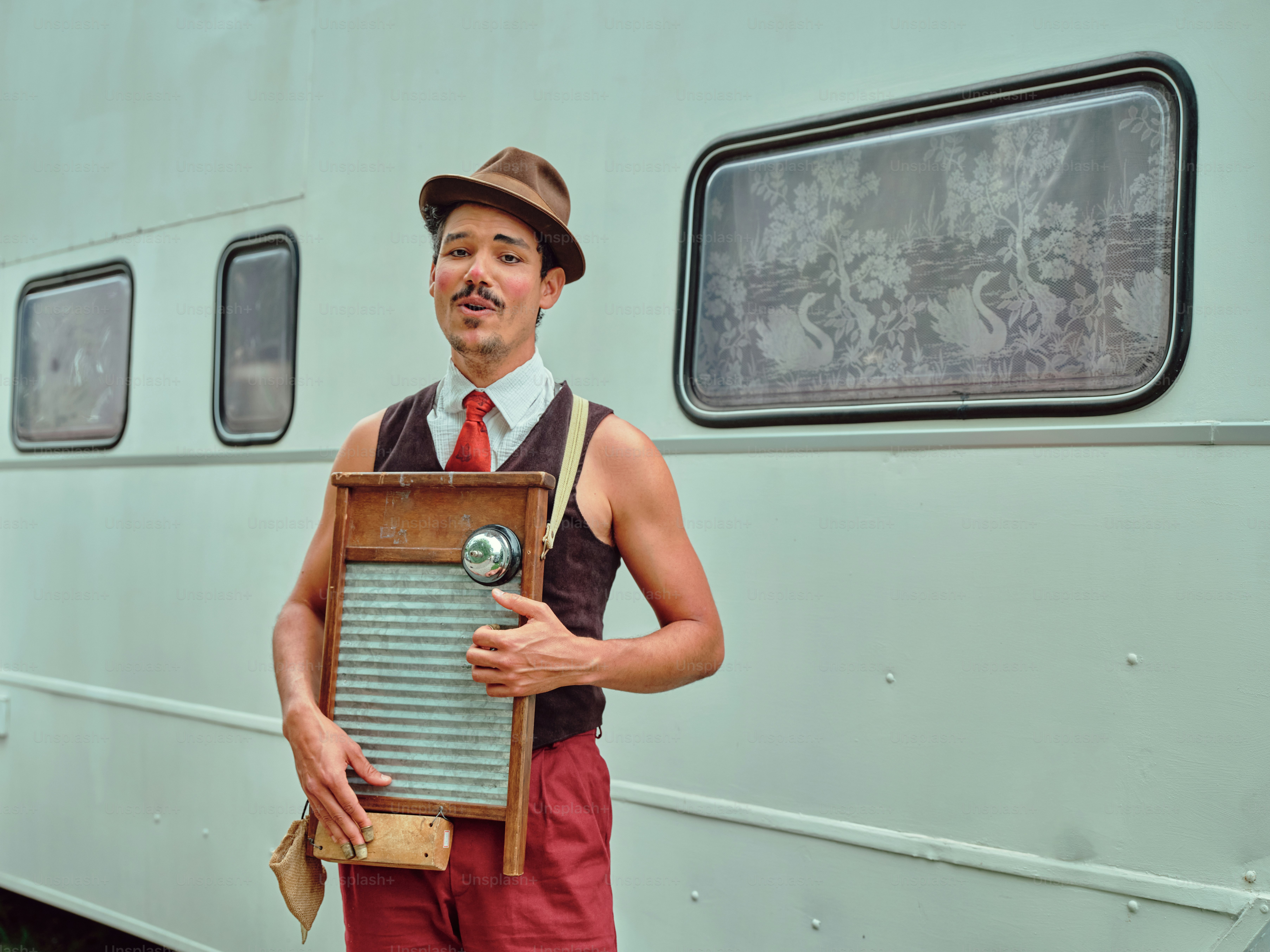 Ein Mann steht vor einem Anhänger und hält eine Plakette in der Hand