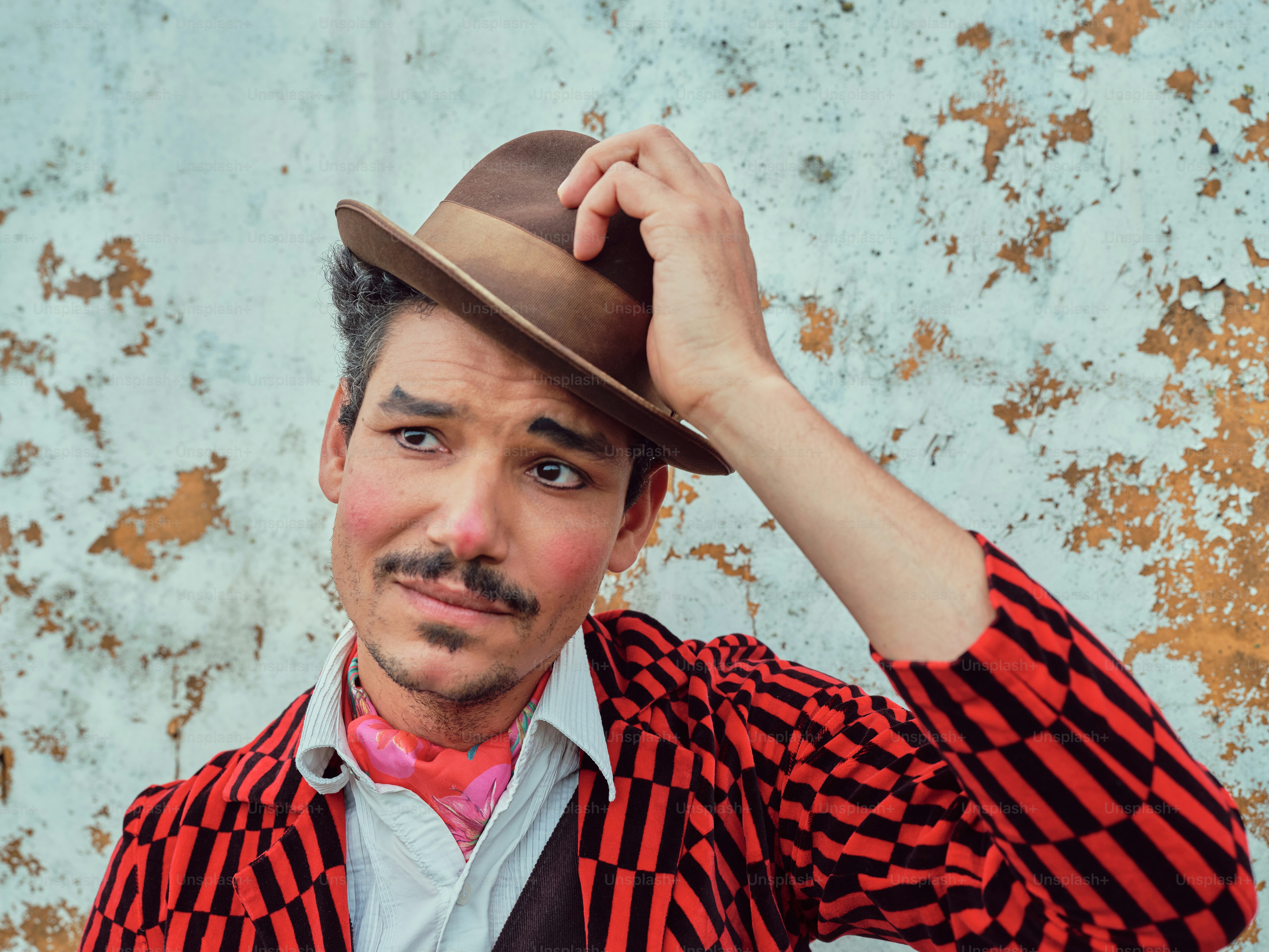 Ein Mann mit Schnurrbart und rot-schwarzem Hemd