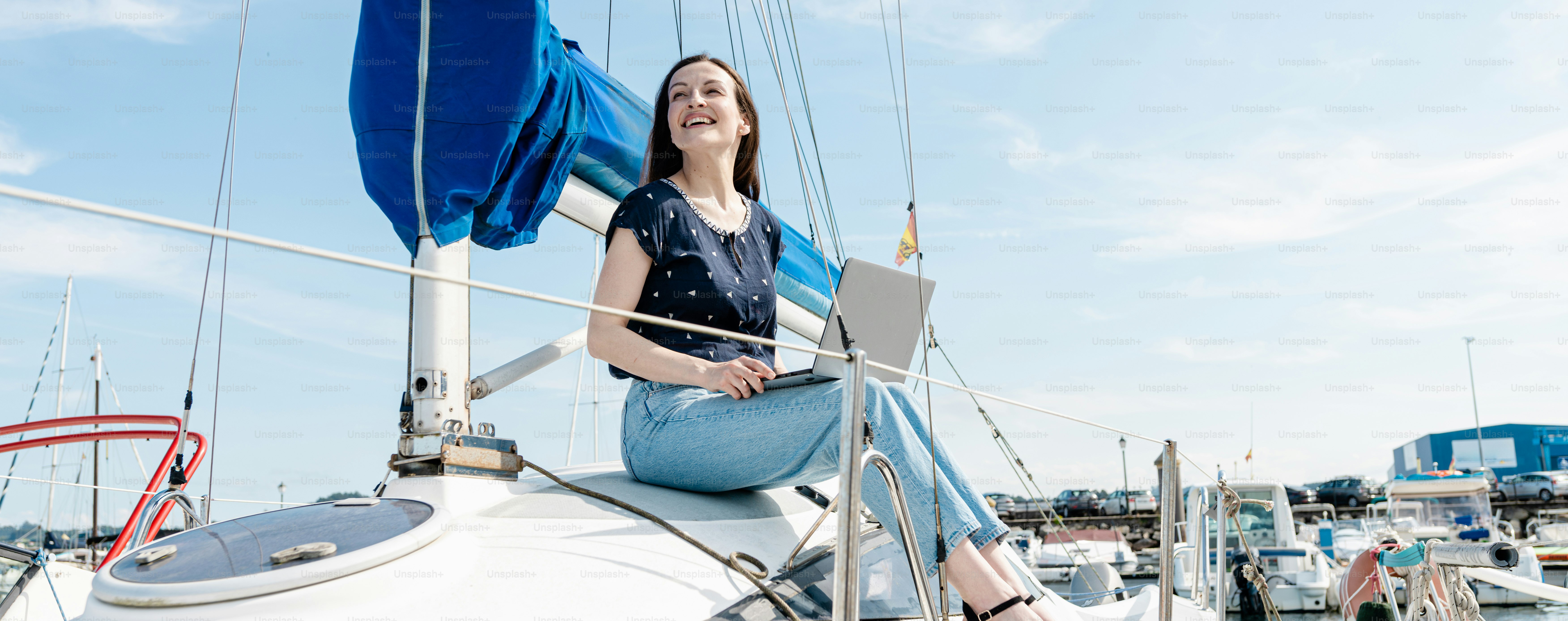 A woman is sitting on a sailboat in the water