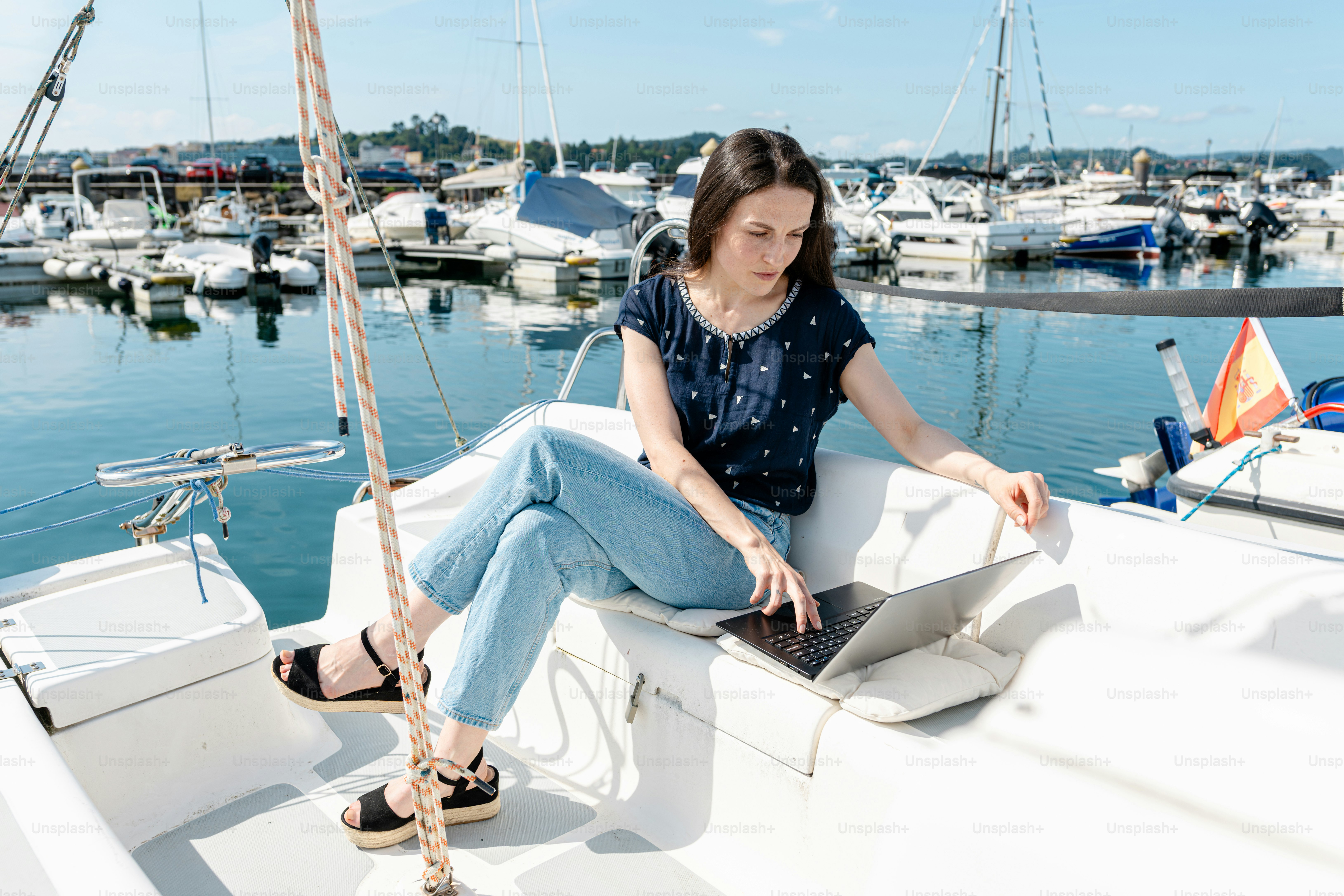 A woman is sitting on a sailboat in the water