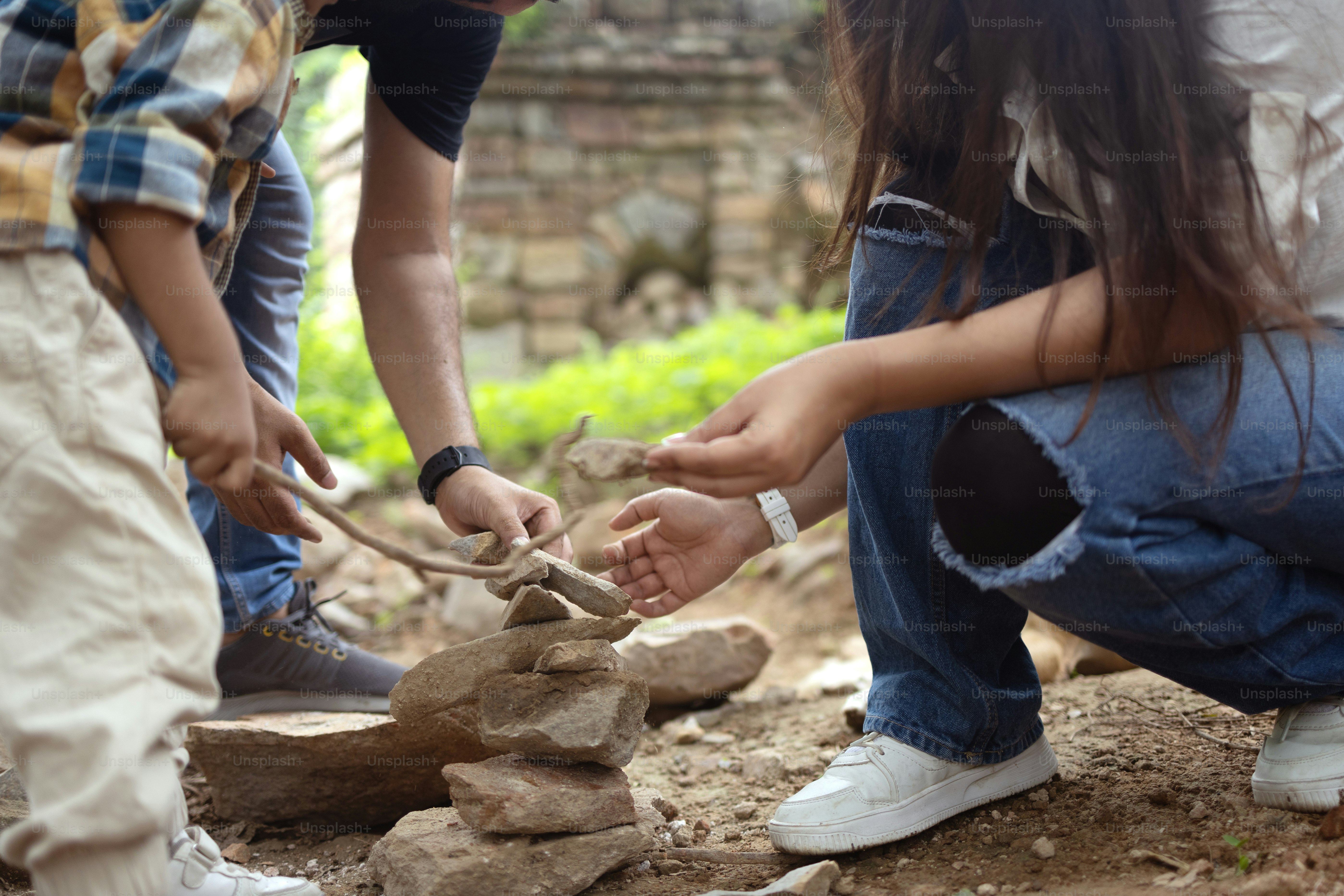 A group of people standing around a stone wall photo – Forest Image on ...