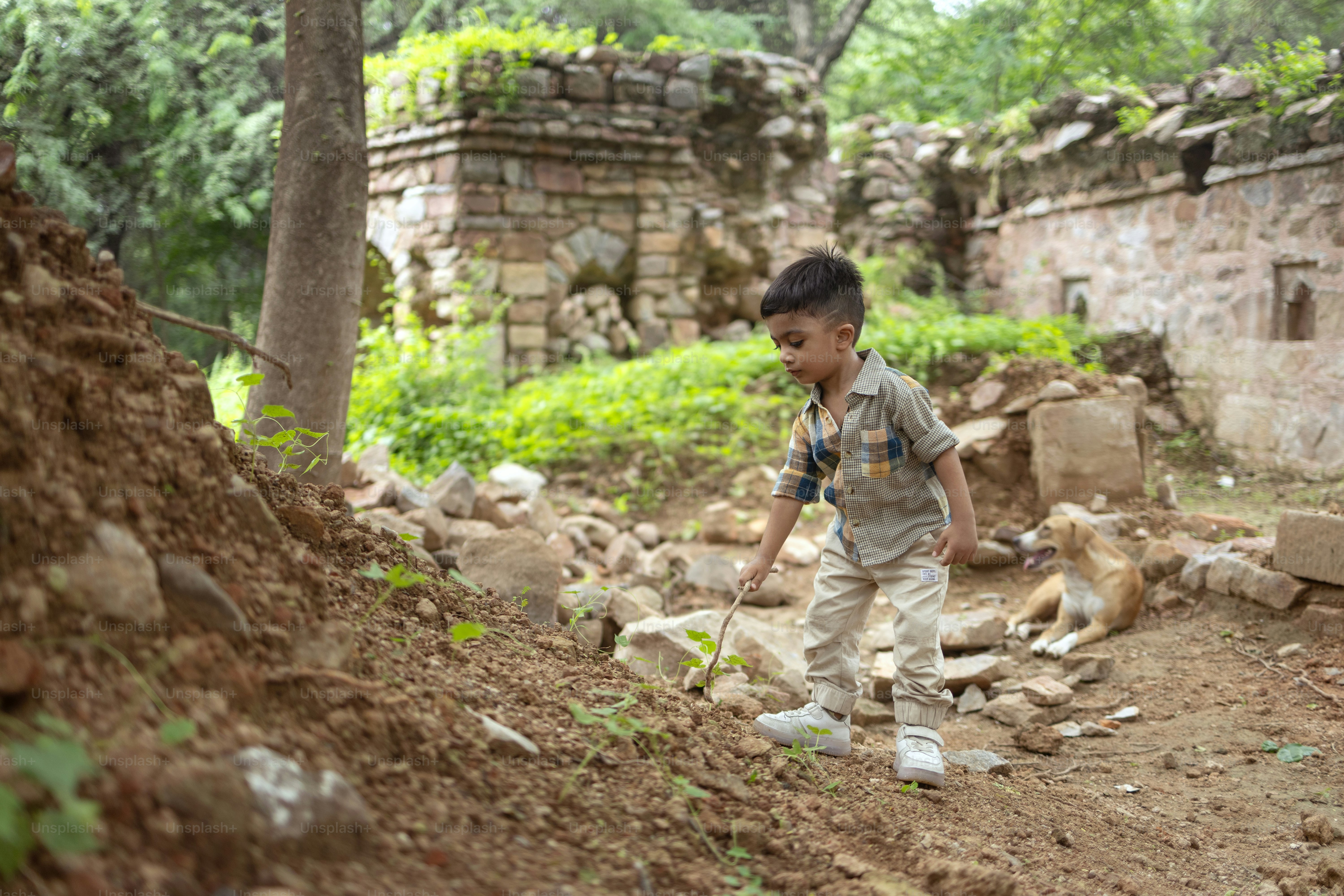 Un niño de pie encima de un montón de tierra