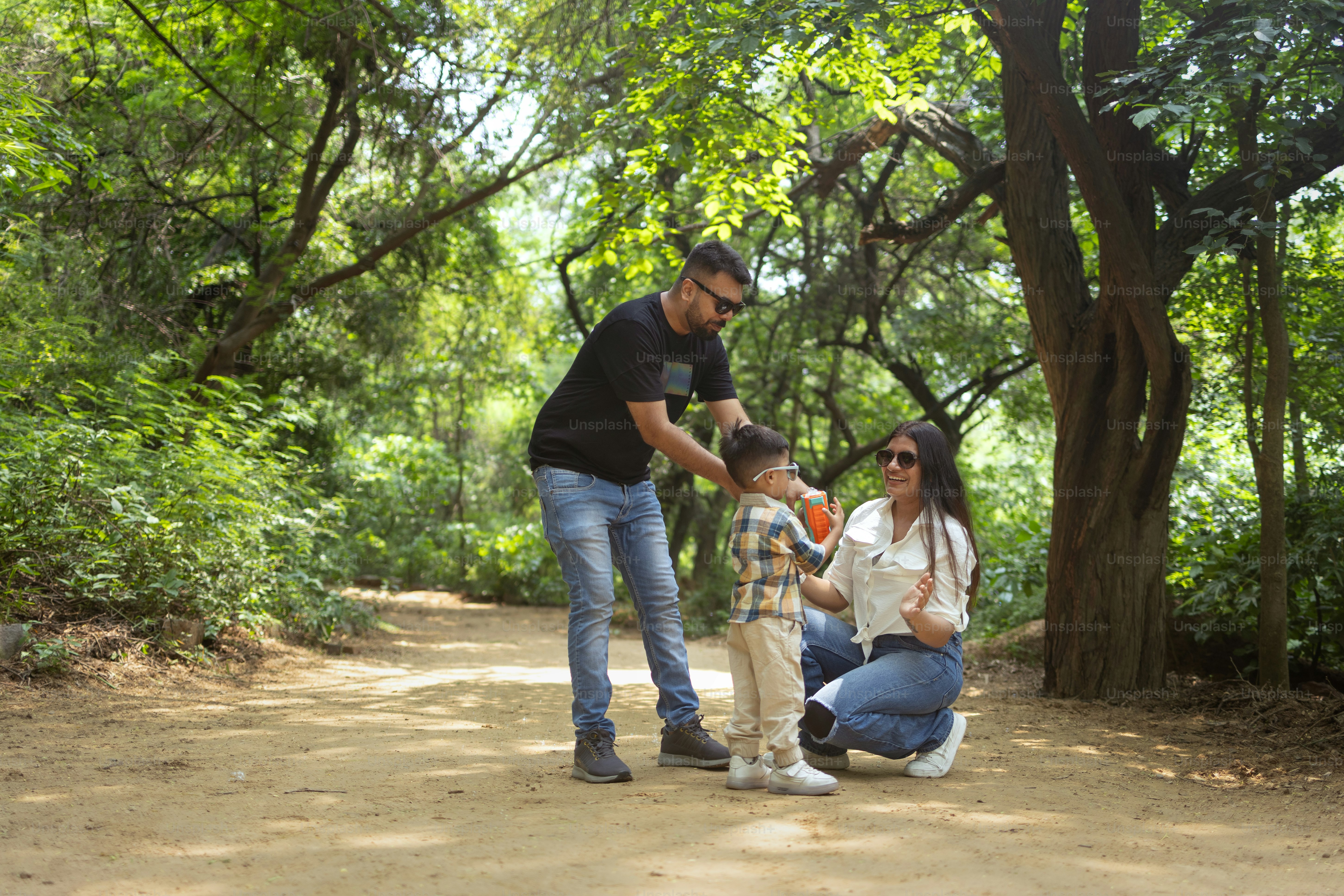 A man and a woman and a child on a dirt road