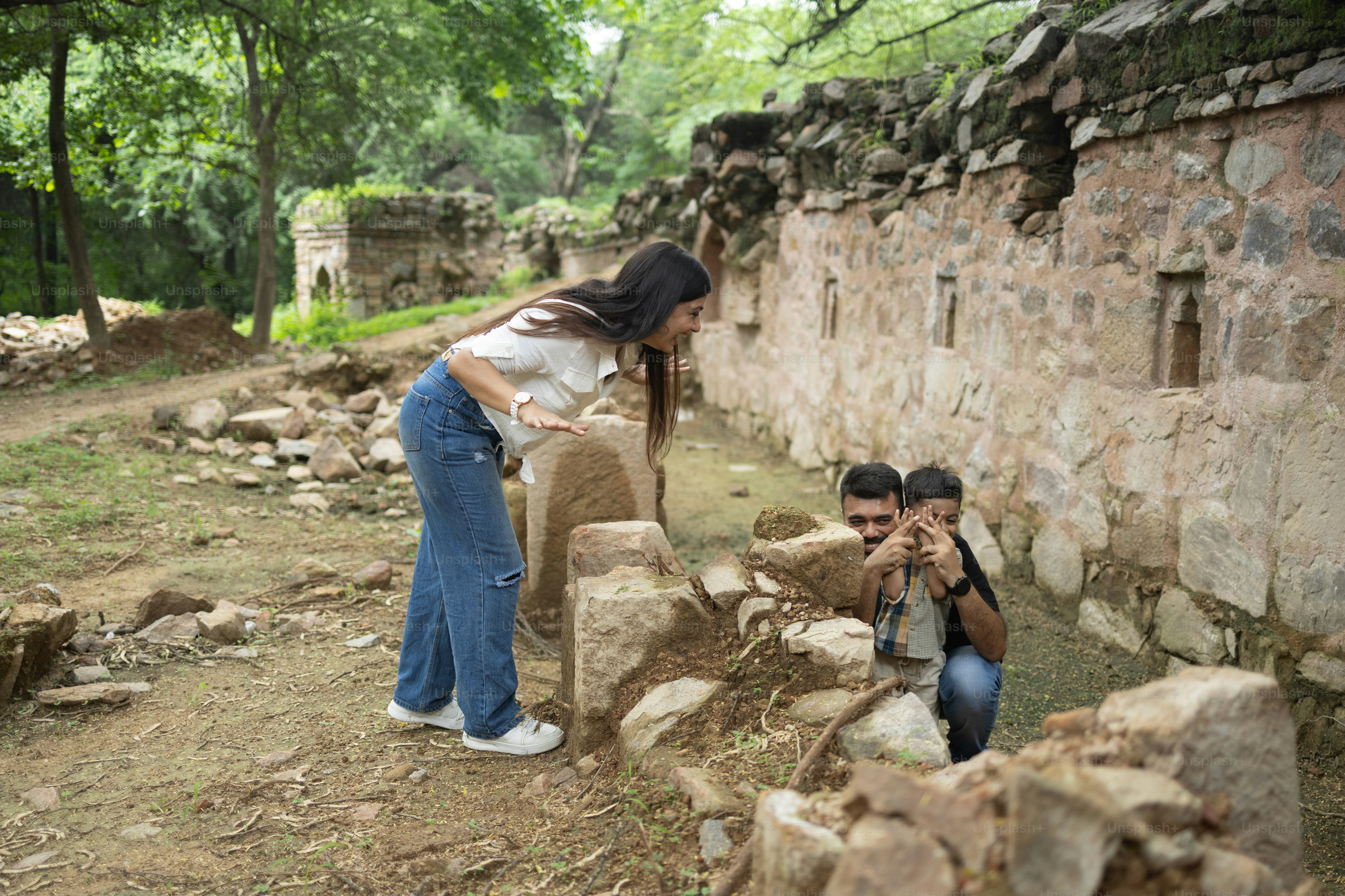 A couple of people standing next to a stone wall